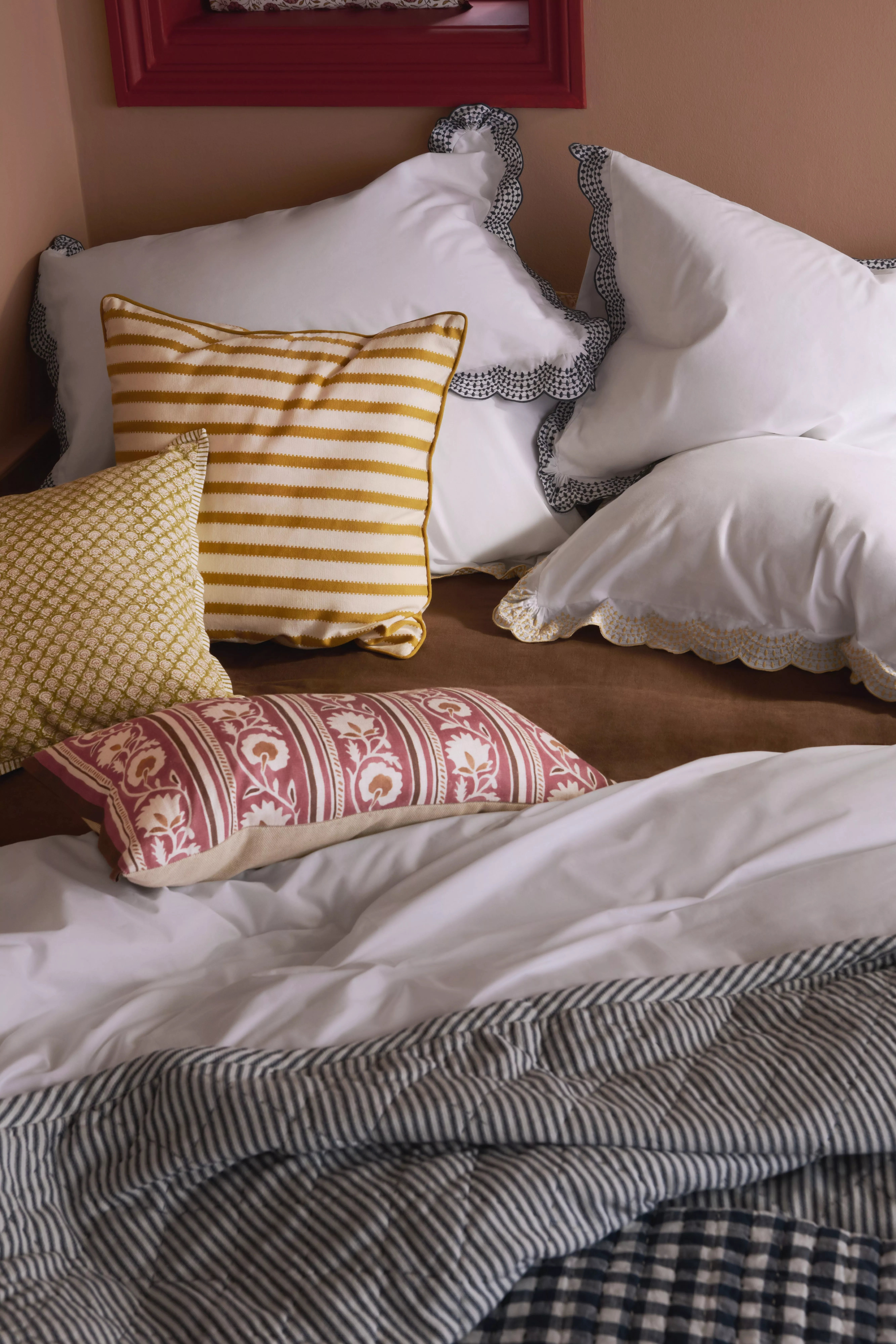 Minimalist bedroom with rattan headboard, white pillow and duvet, bedside lamp, soft natural light
