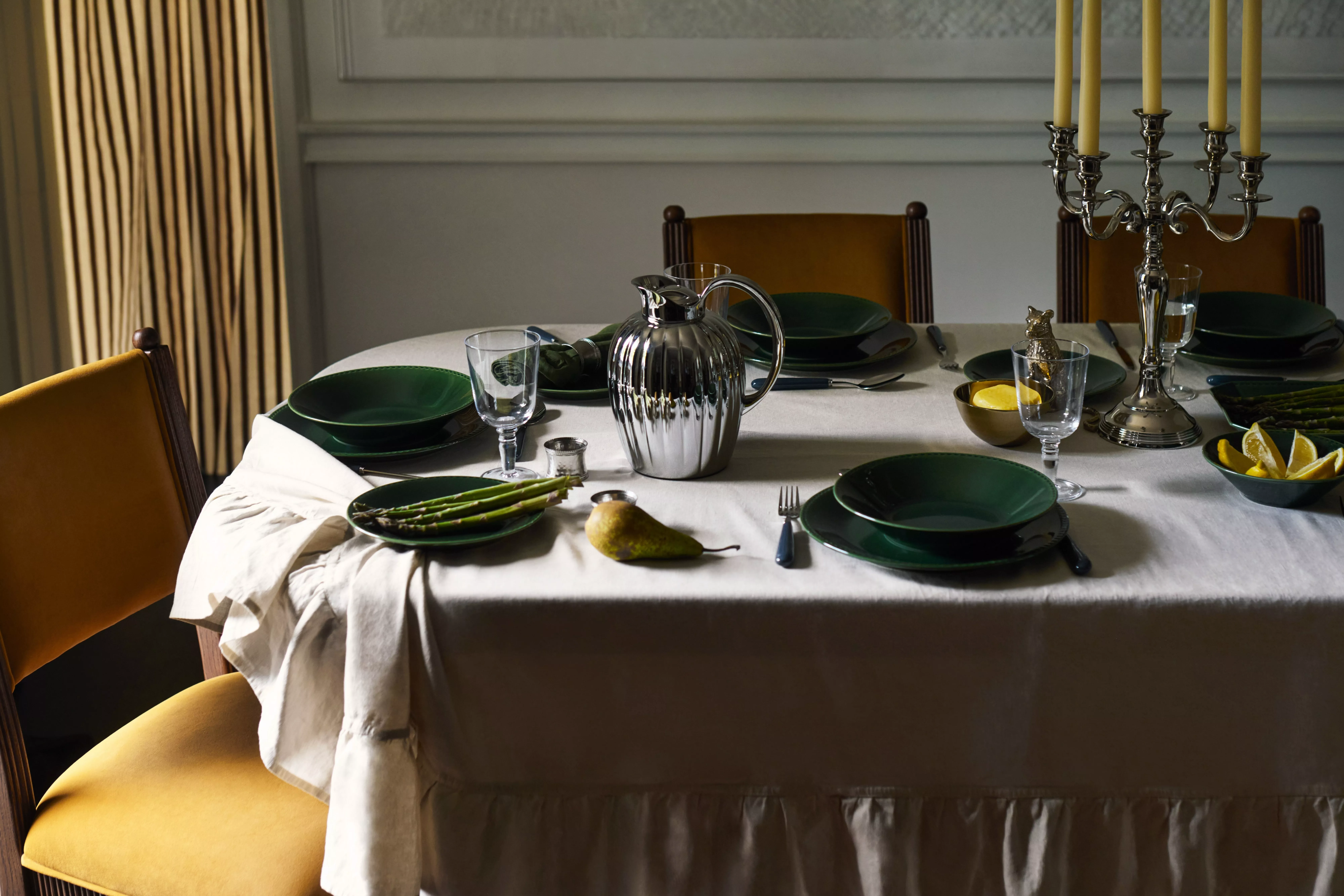 Modern dining room with wood panelling, oak table, green chairs, pendant light and framed artwork