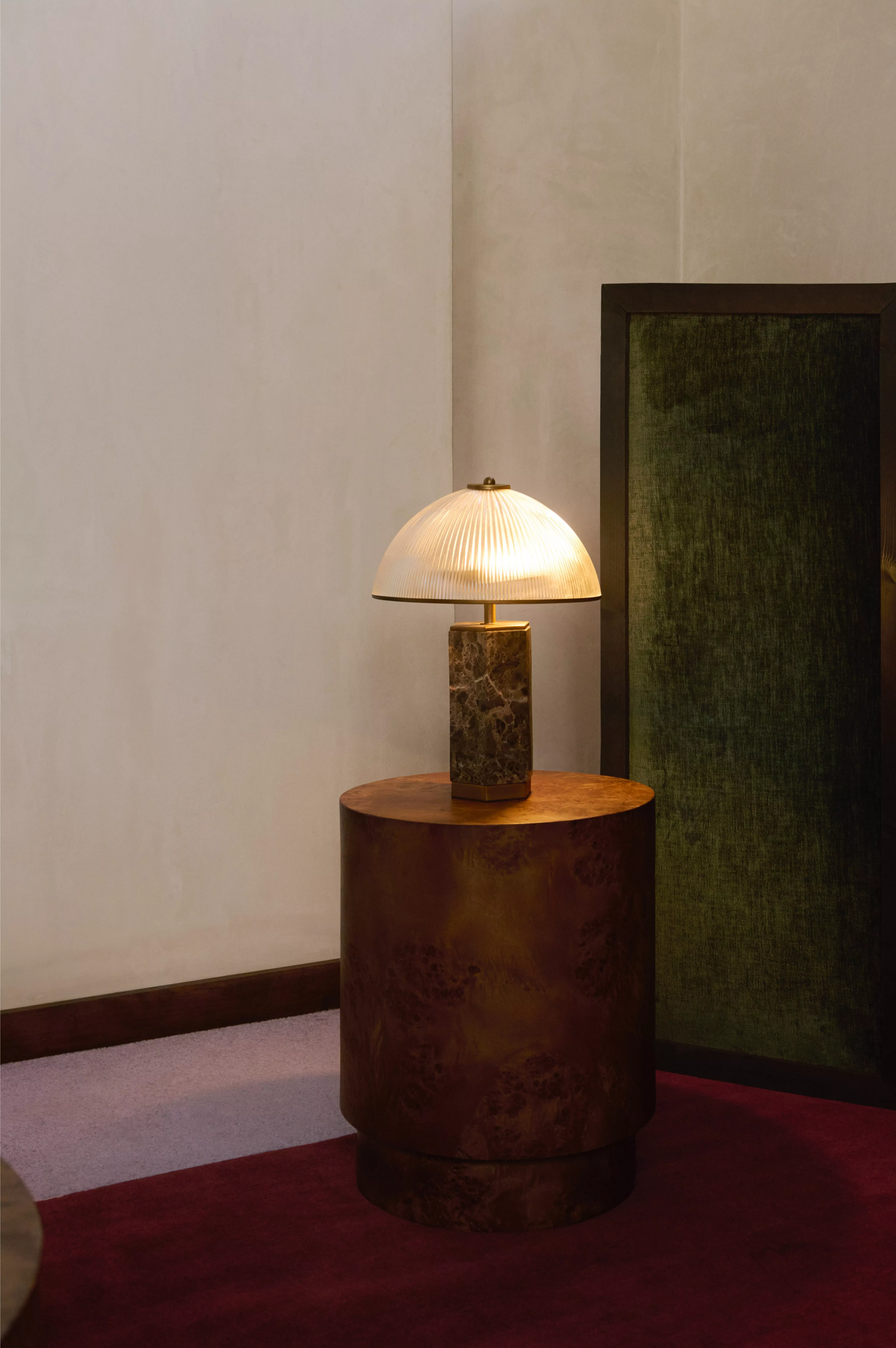 Stylish wooden side table with a modern lamp featuring a textured green base and beige shade. Elegant room decor.