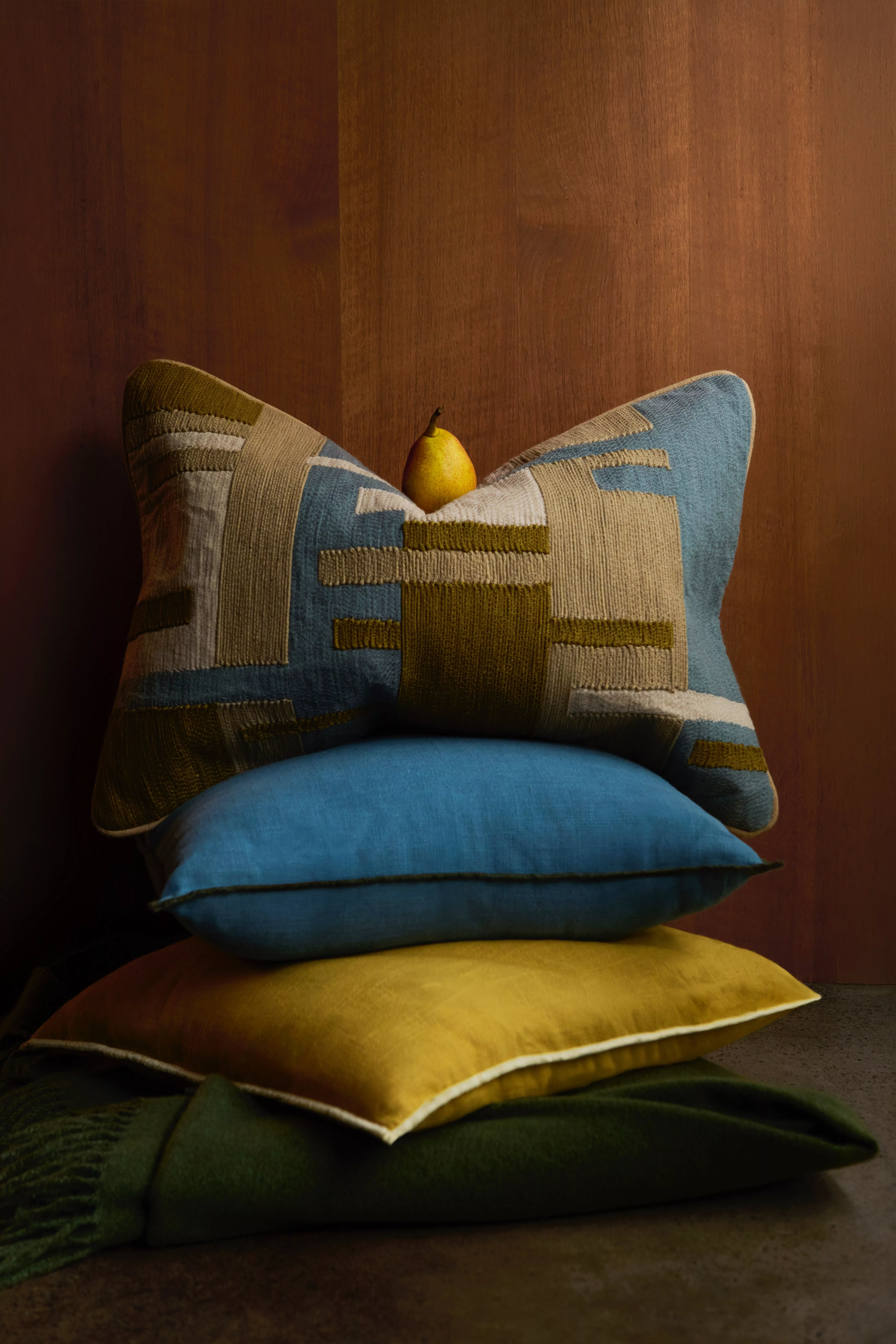 Beige sofa with colourful patterned cushions and knitted throw, cosy living room interior decor close-up