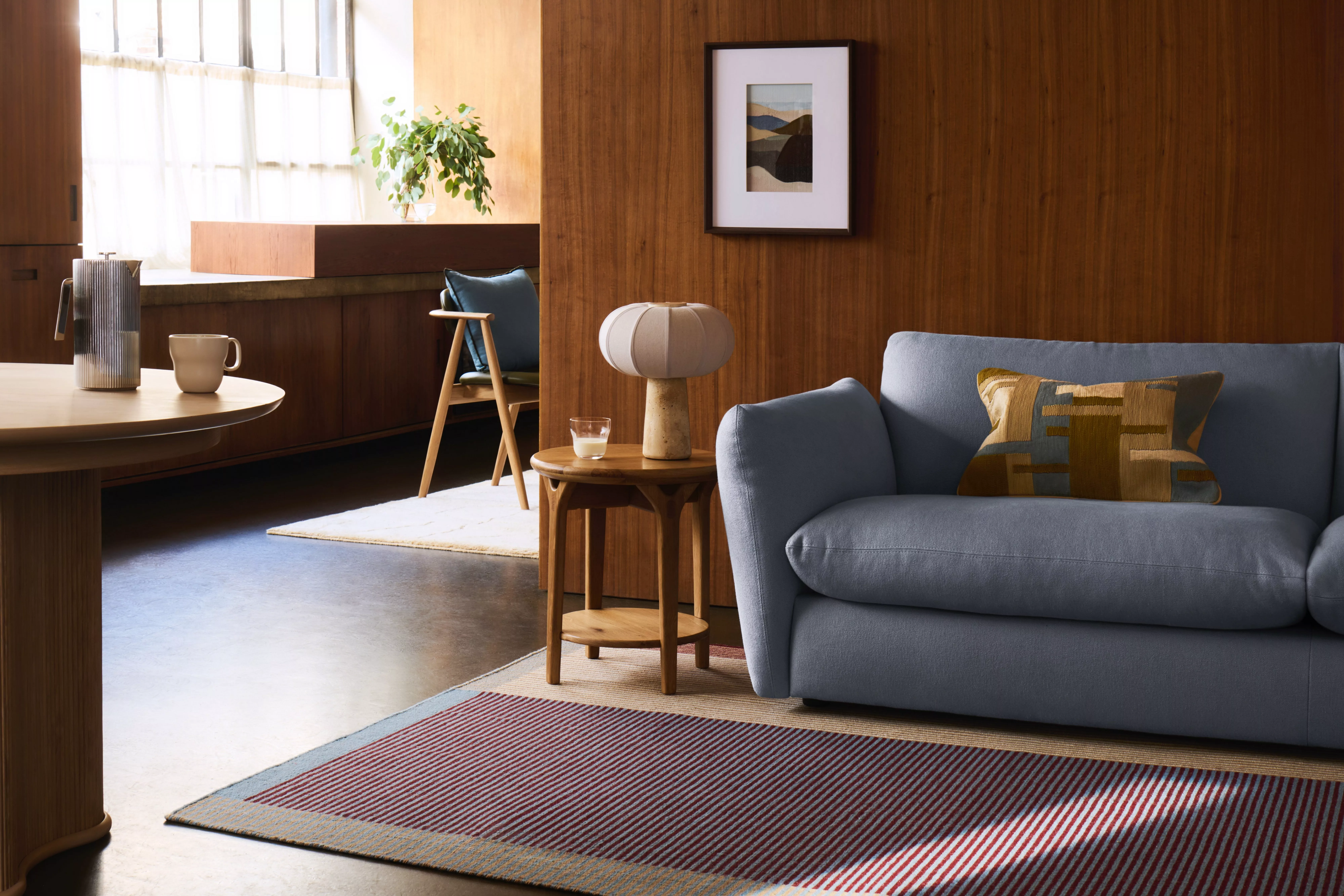 light and airy living room styled with a blue sofa, a cream sofa, wooden furniture, and a mix of colourful accents