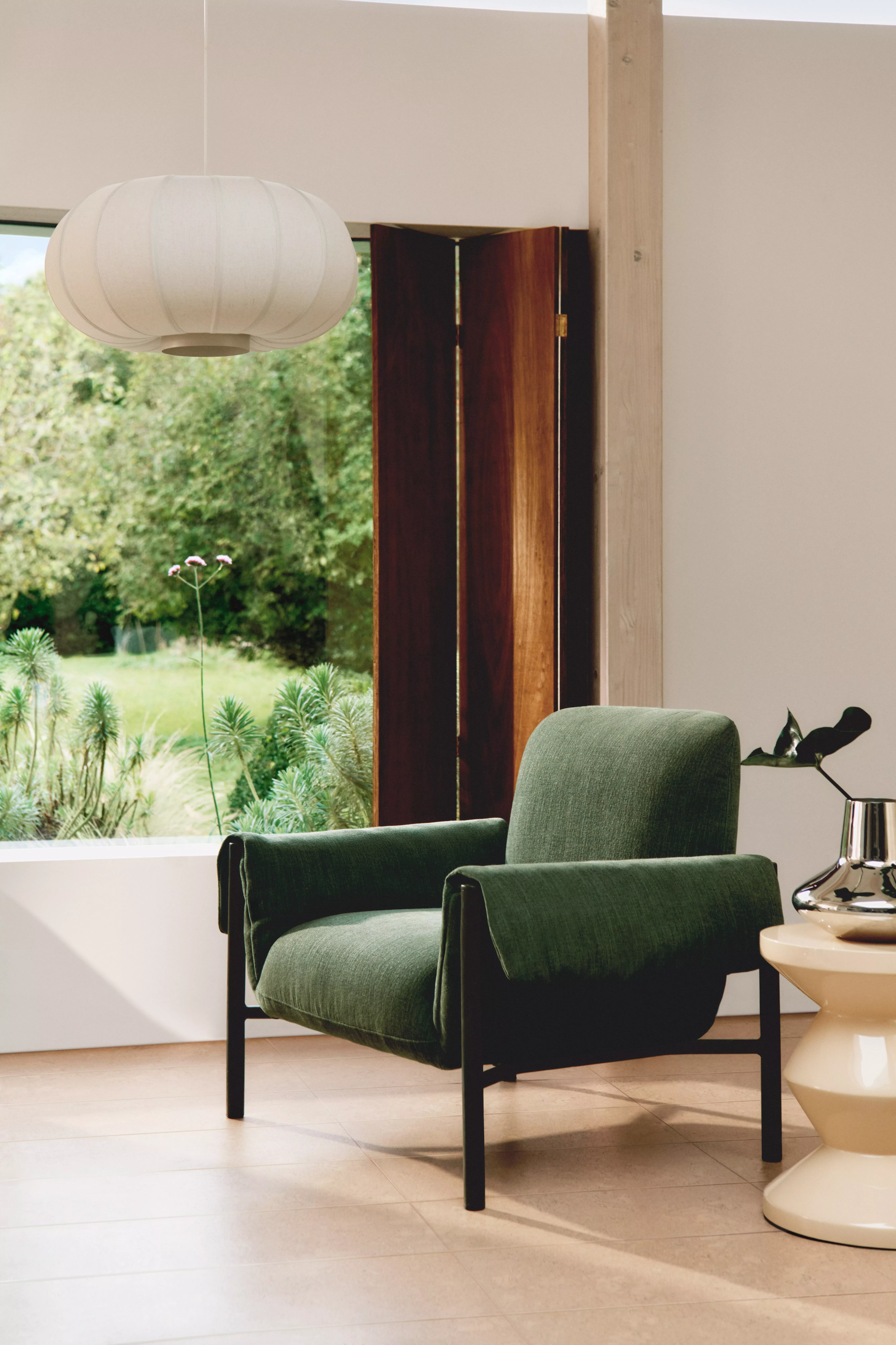 Green armchair in front of an open window