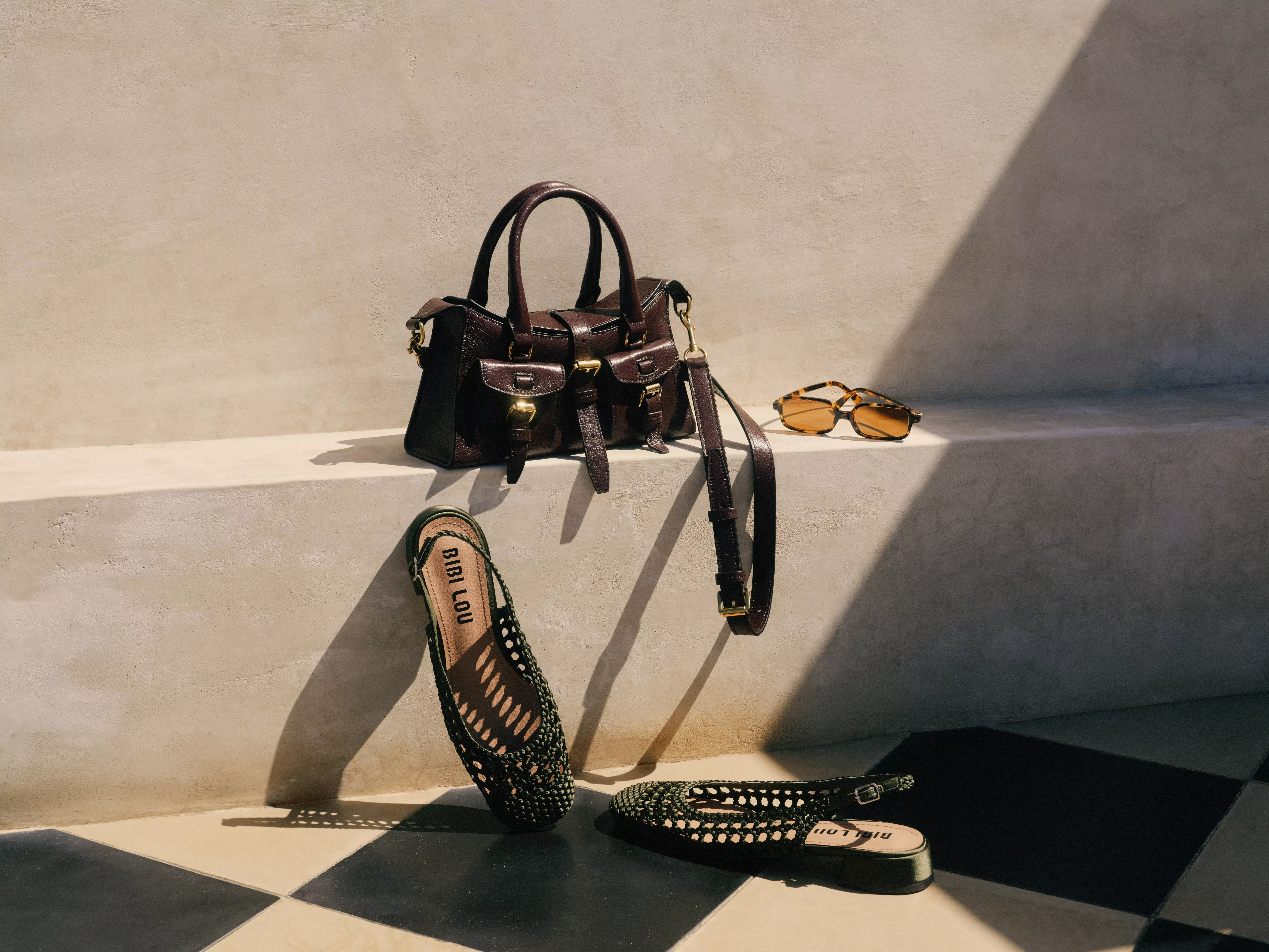 Luxury leather handbag with sunglasses and woven flats on sunlit steps, stylish fashion still life scene
