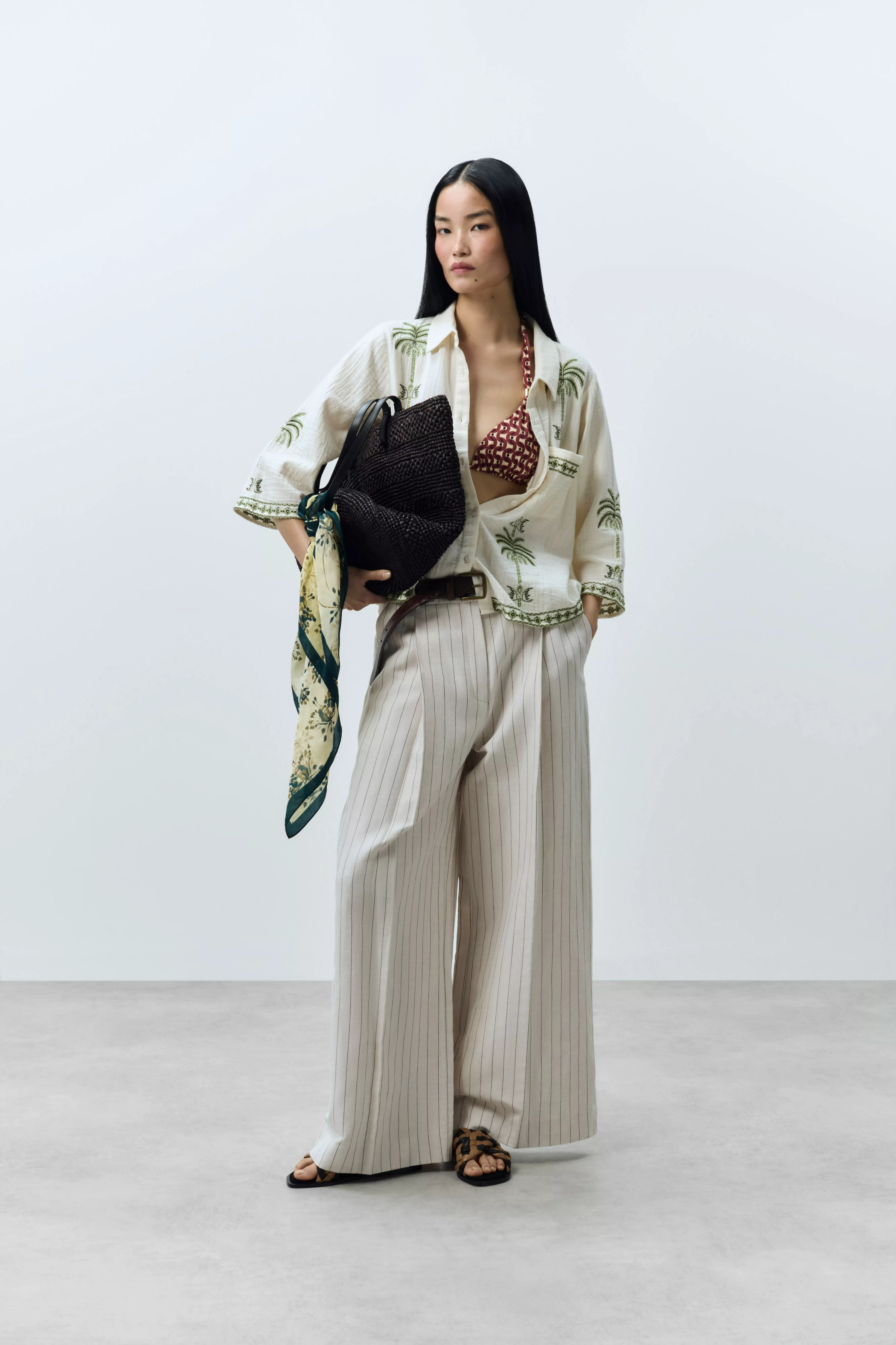 women wearing biege linen trousers with floral shirt