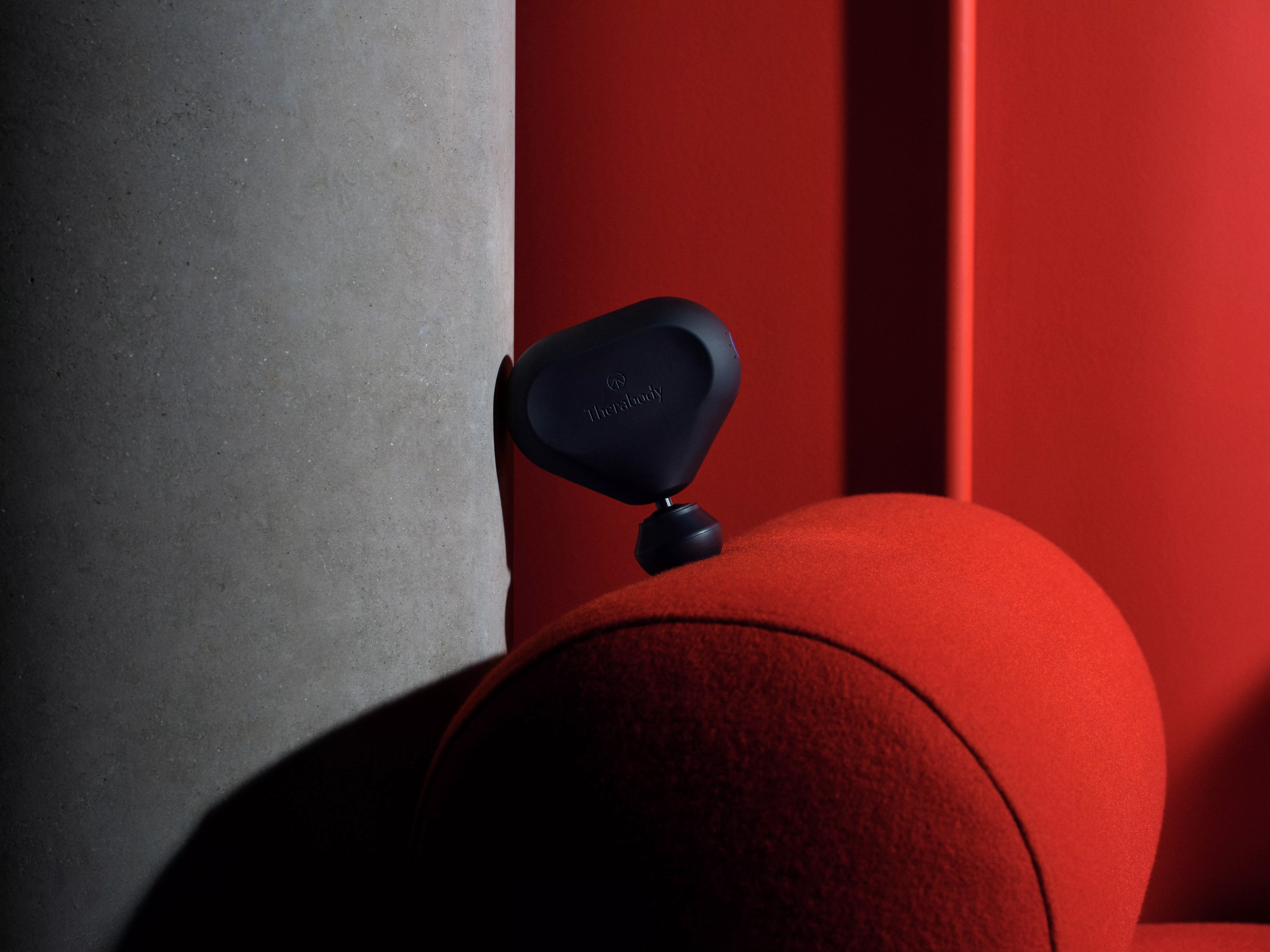 man holding a sports massager against his calf muscle