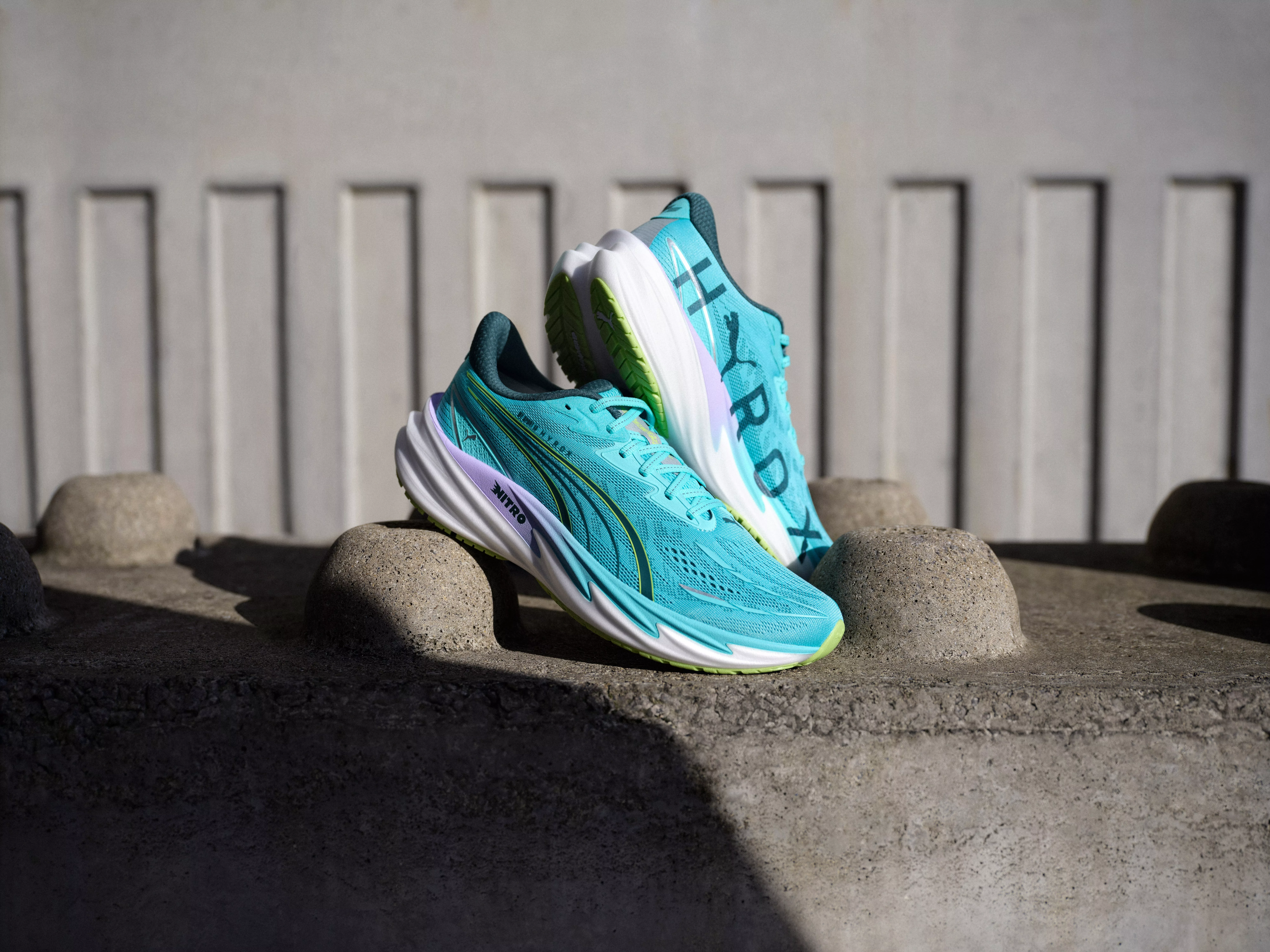 Turquoise Puma Nitro running shoes on concrete steps, lightweight cushioned trainers for road running performance