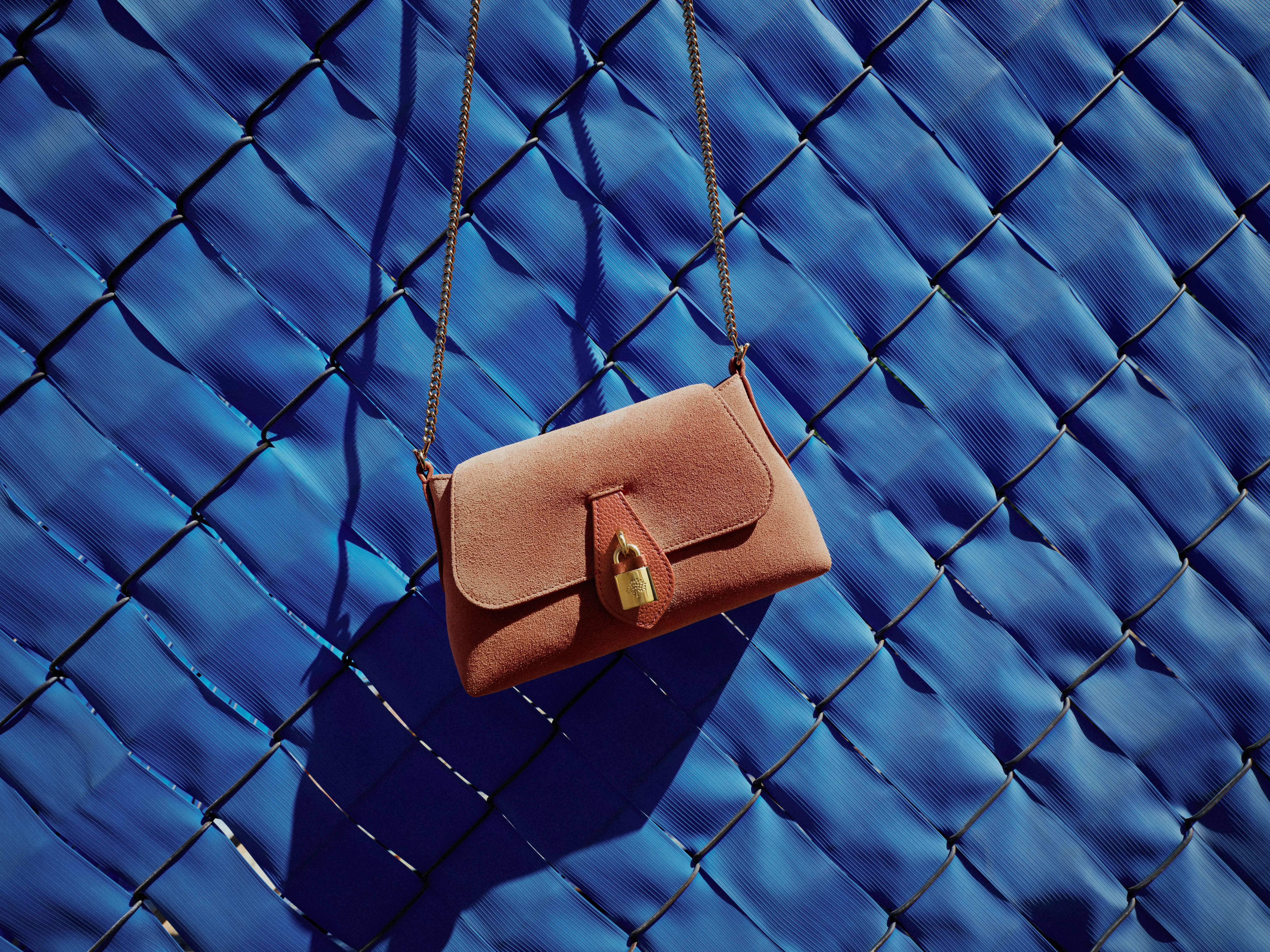 pink suede shoulder bag with a chain strap