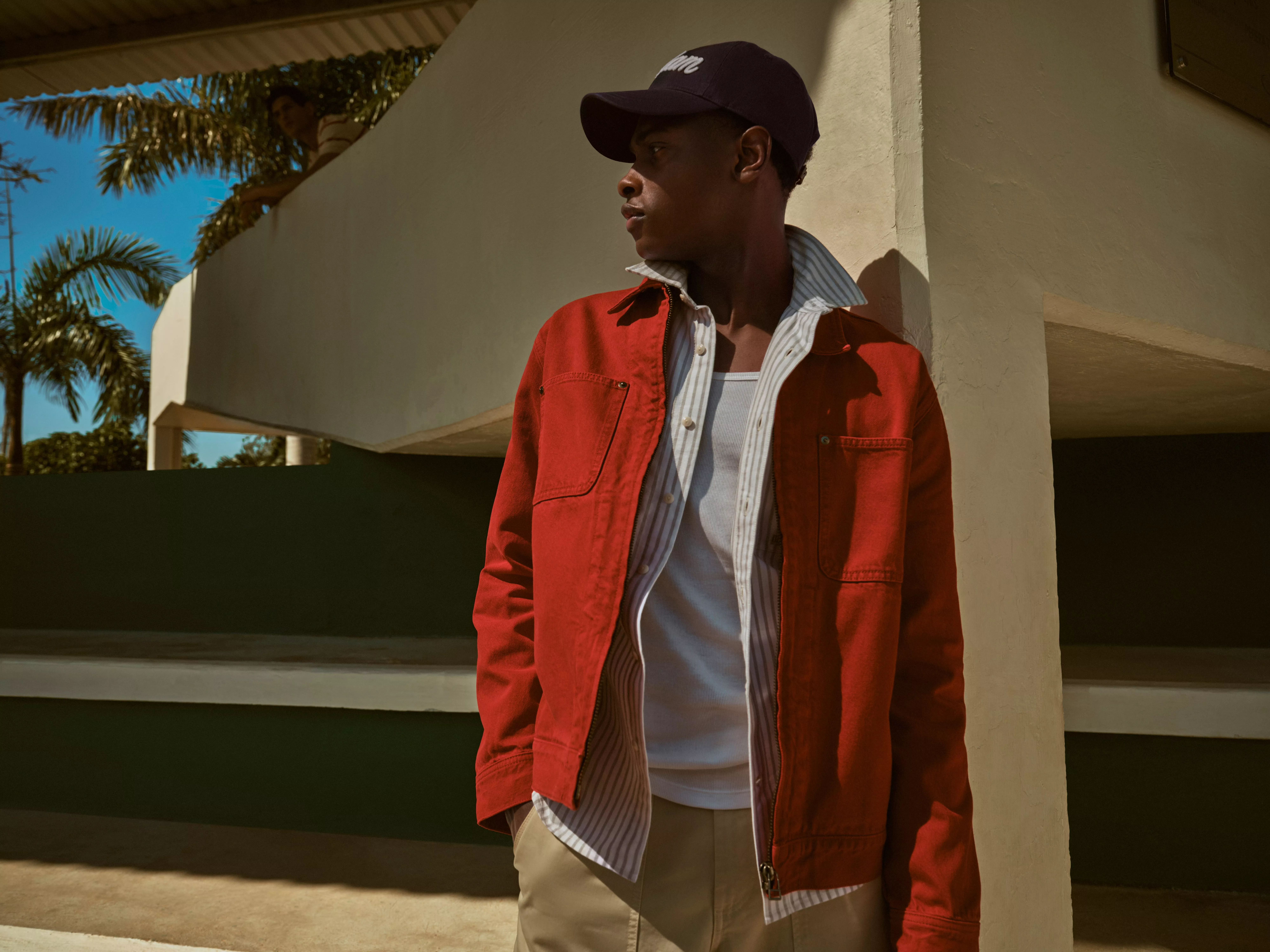 Man wearing a red jacket over a shirt and vest