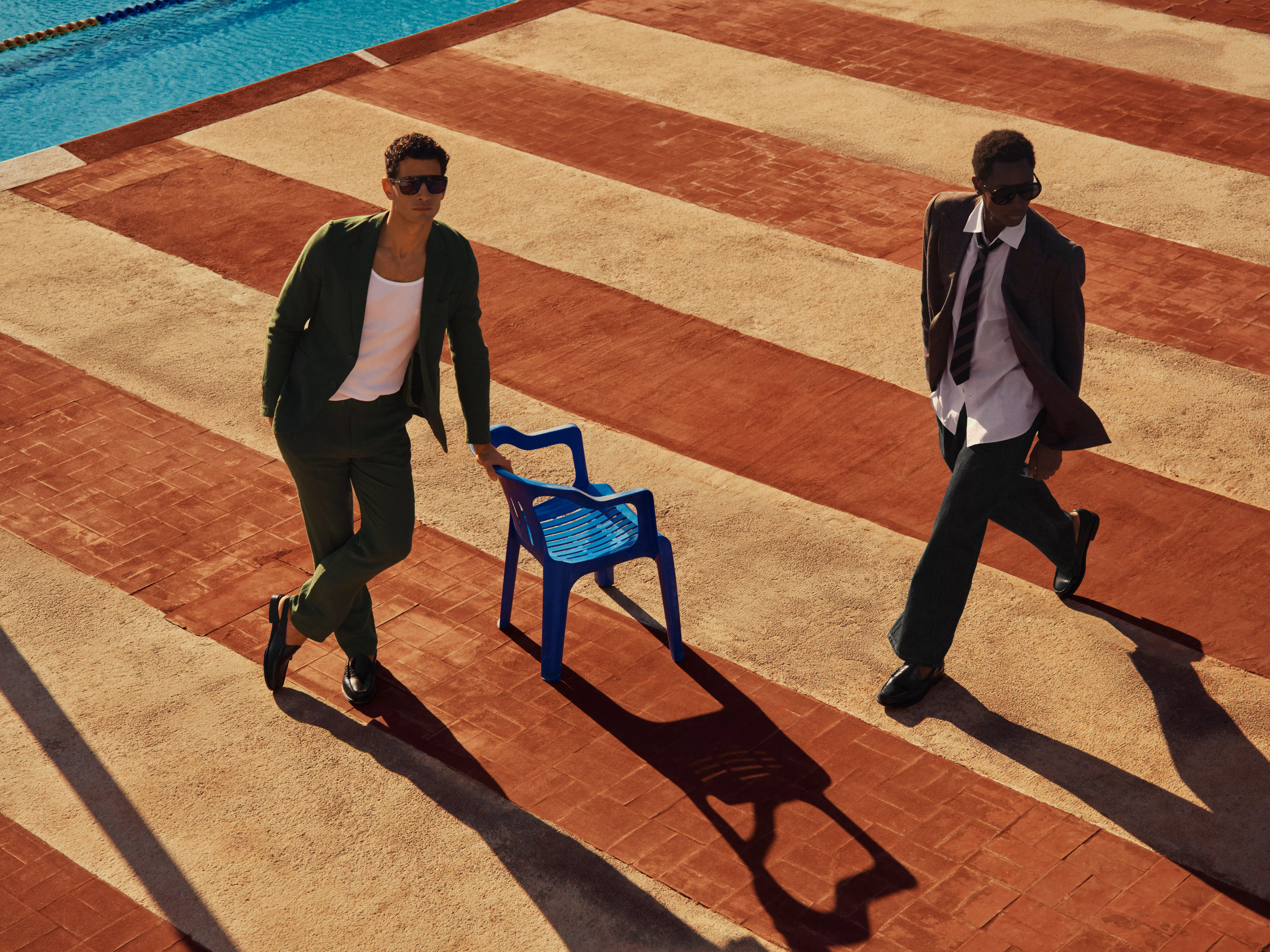 Man wearing a blazer, vest, trousers and sunglasses