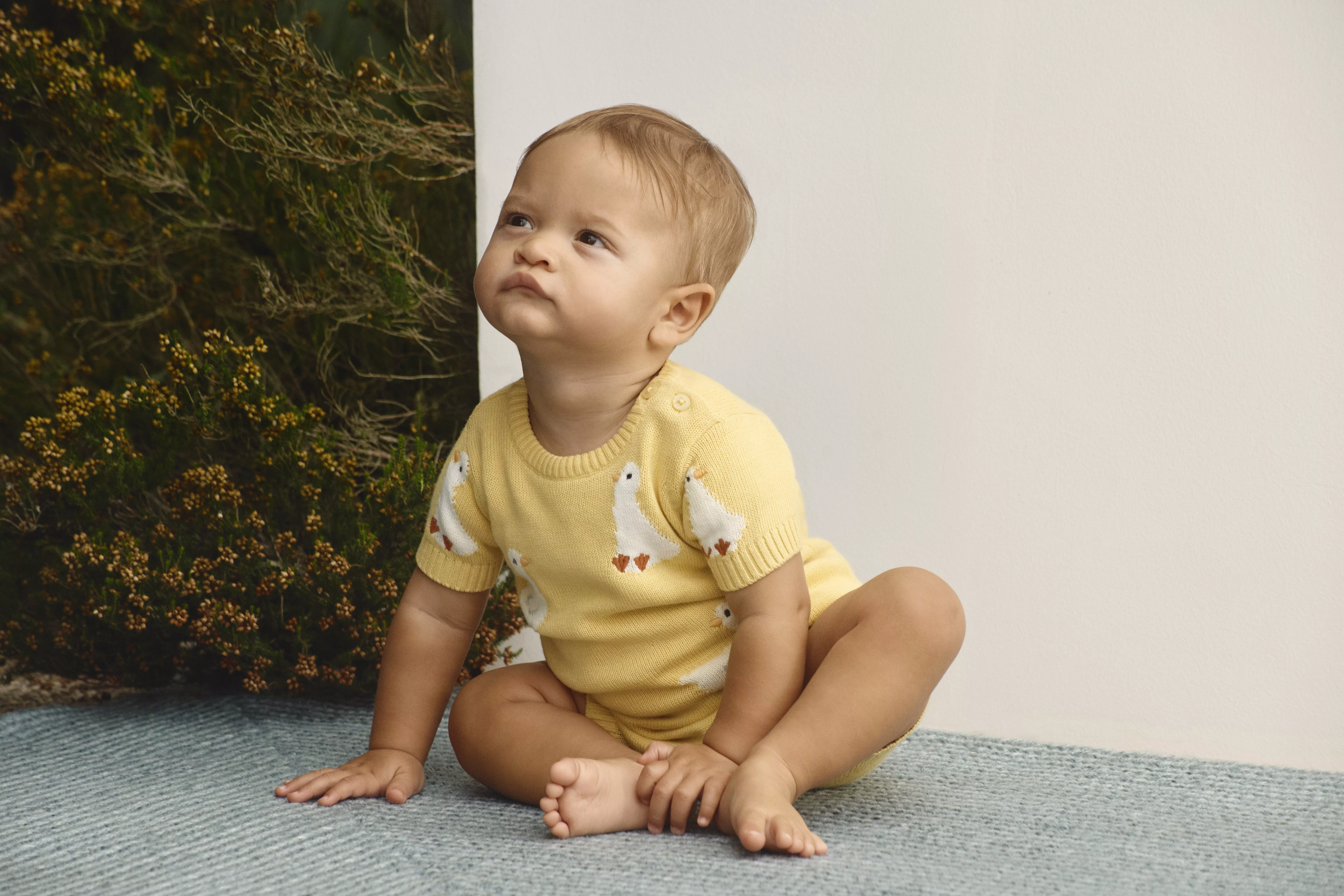 baby girl wearing a yellow bodysuit 