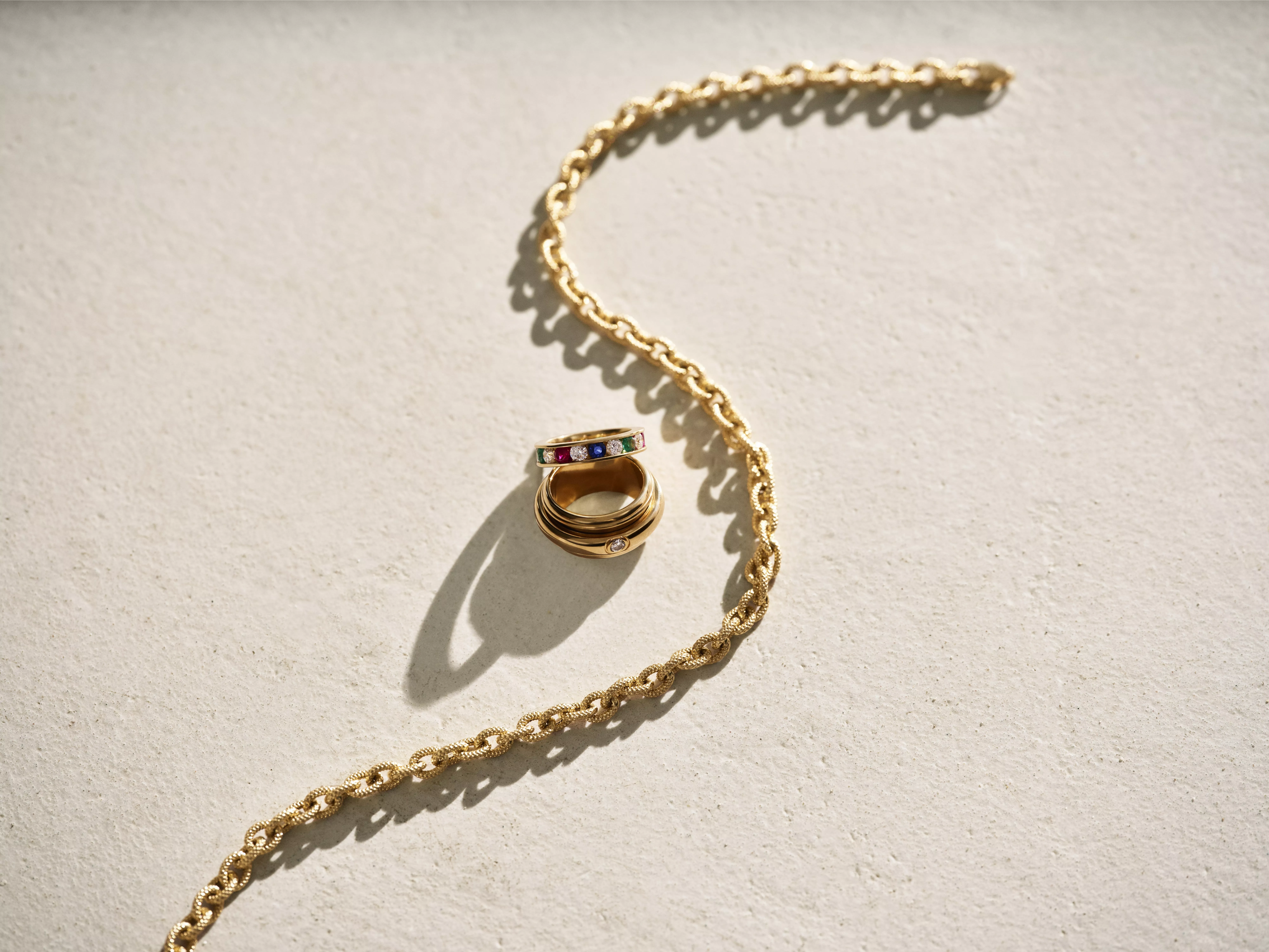 Gold chain with a gold ring next to it 