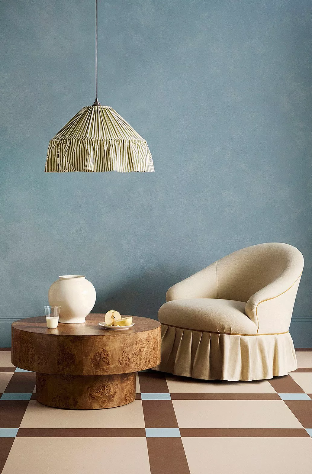 Elegant table setting with teal plates, cutlery, and a white egg-shaped item. Floral tablecloth enhances decor.