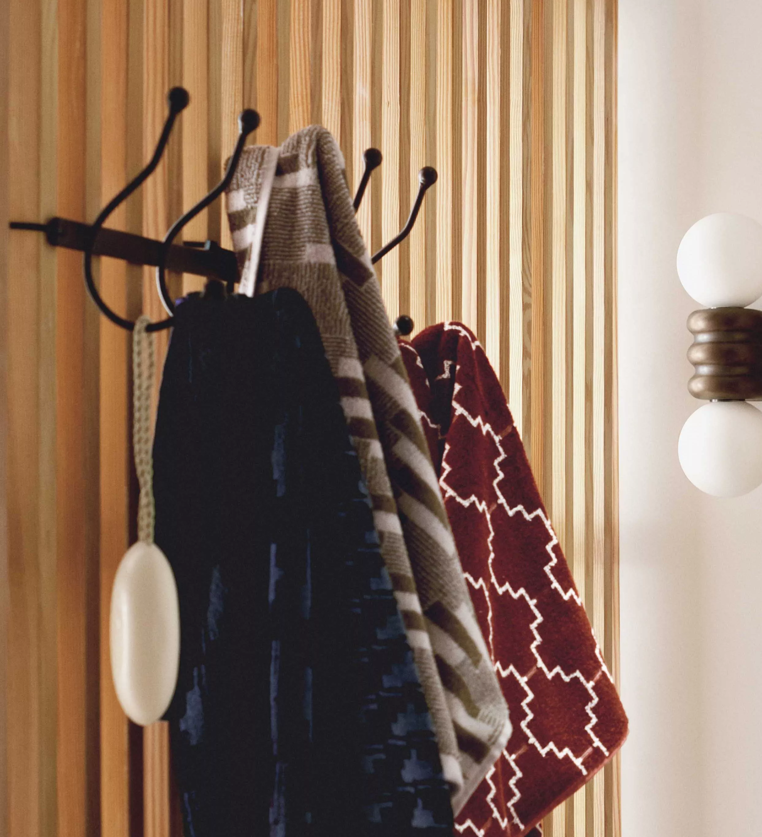 Silver hook attached to a wall with a towel hung up on it 