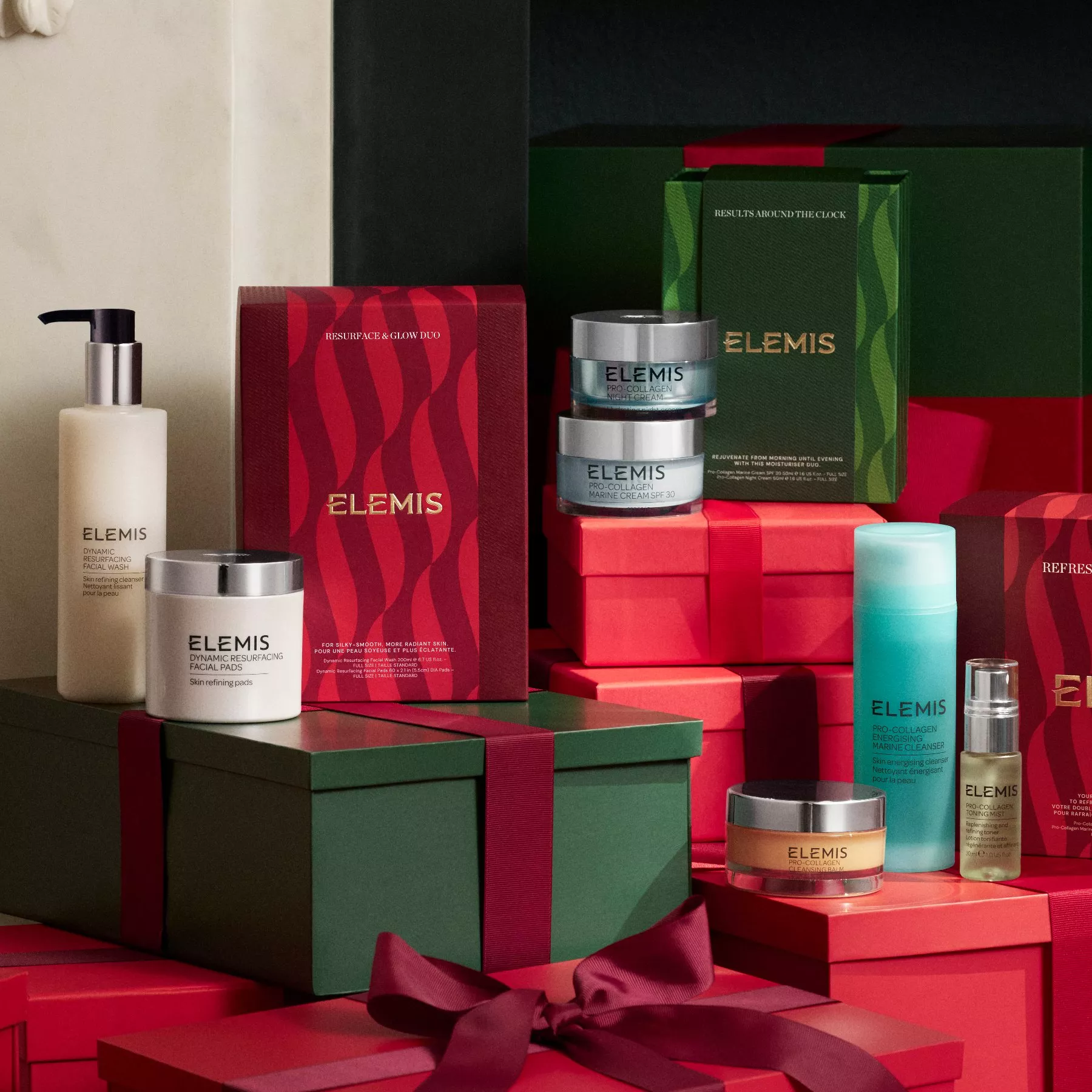 Elemis skincare gift set display with Pro-Collagen creams, cleansers and festive red and green present boxes.