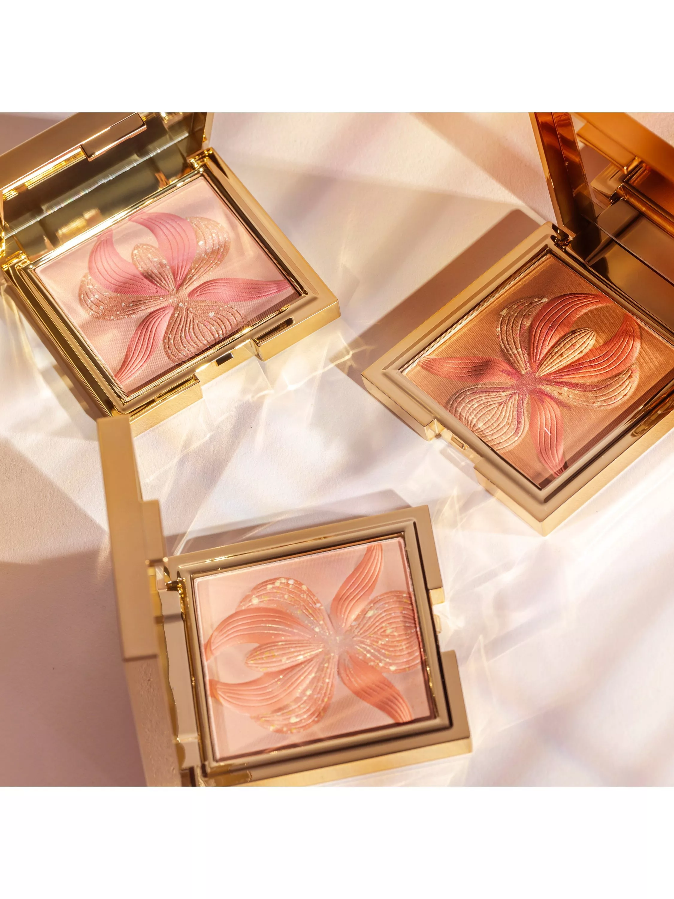 three pastel pink blushes in gold packaging