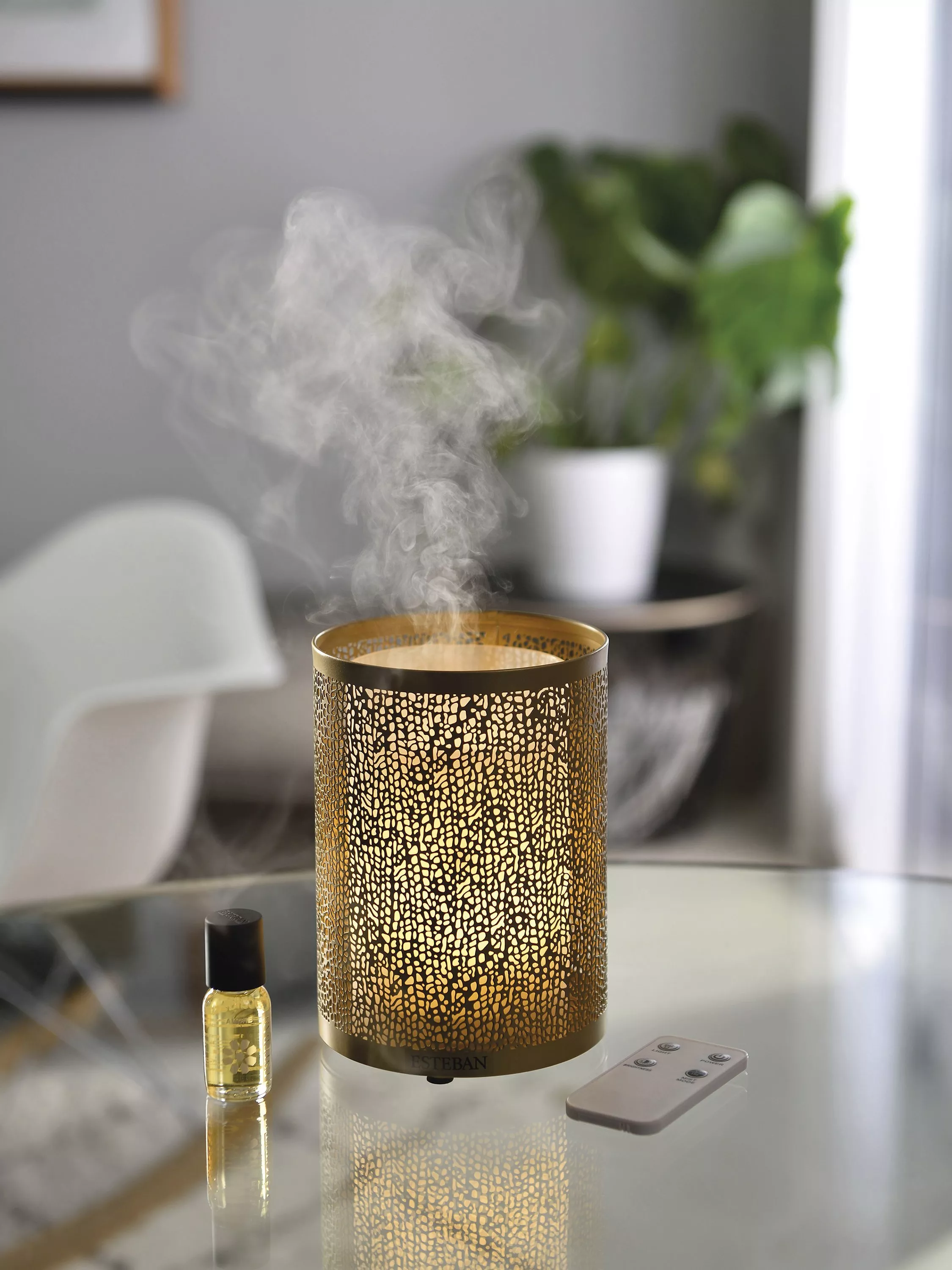 Lit CALM scented candle in frosted glass on a woven tray, with eucalyptus stems in soft natural light