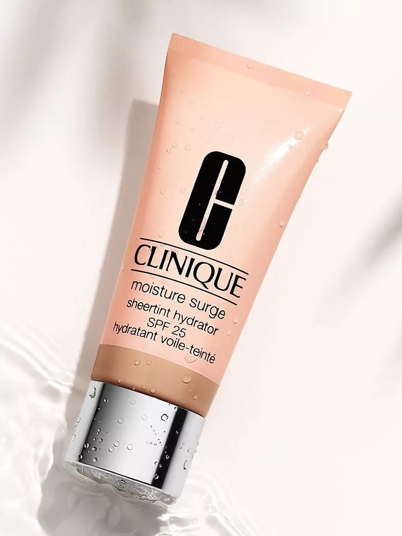 Clinique Moisture Surge Sheertint Hydrator SPF 25 tube on wet surface with tinted moisturiser swatch