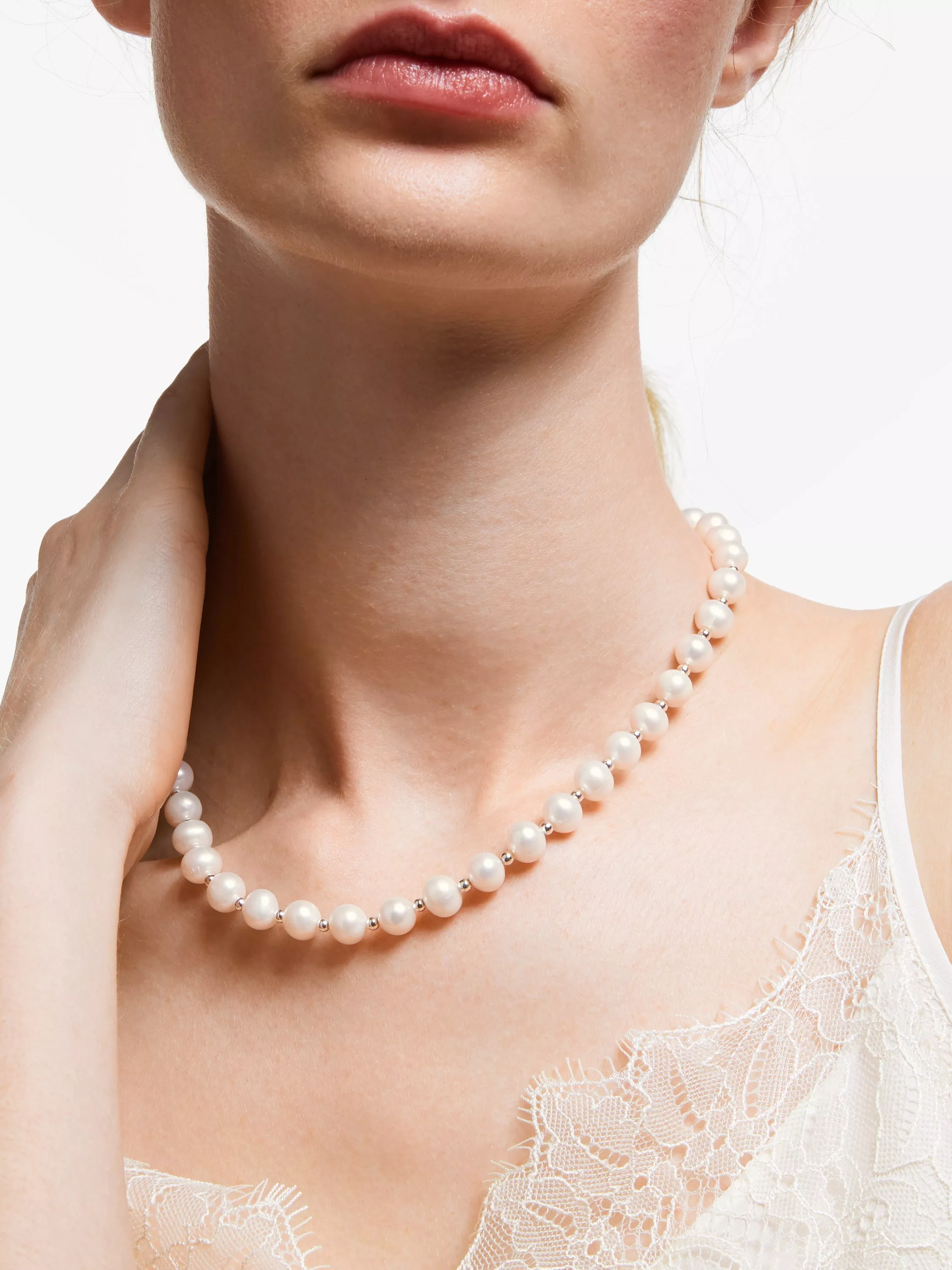 Close-up of woman wearing diamond and pearl drop earring, elegant bridal jewellery on ear and jawline
