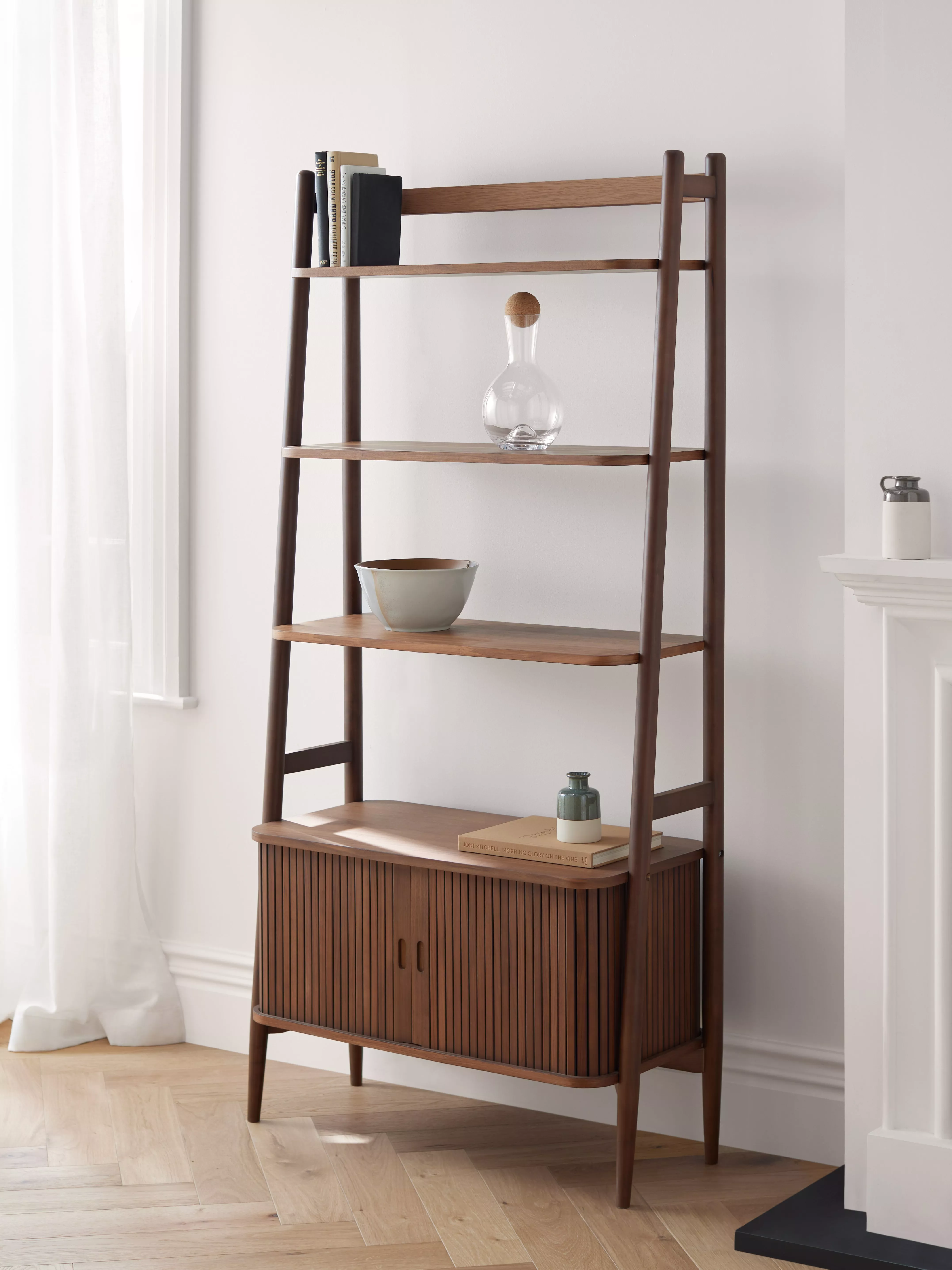 Dark wood ladder shelf with cabinet at the bottom