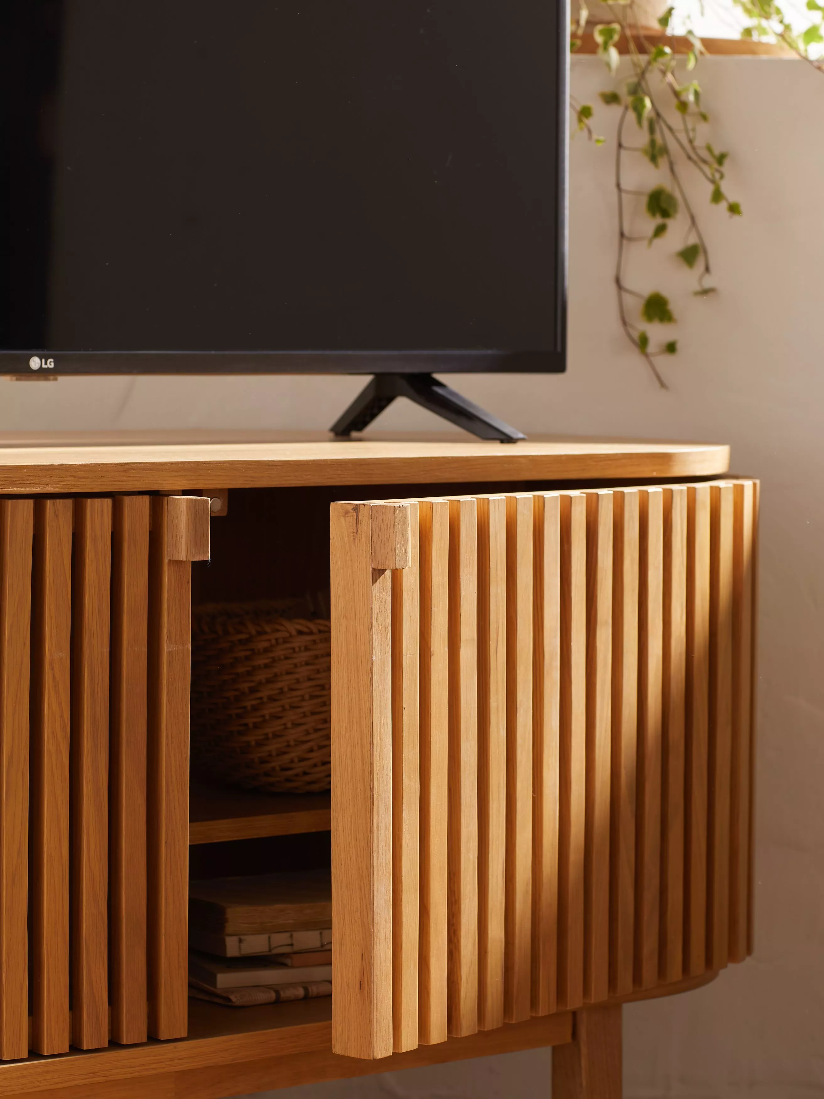 Wooden slatted TV stand with cupboard and TV on top 