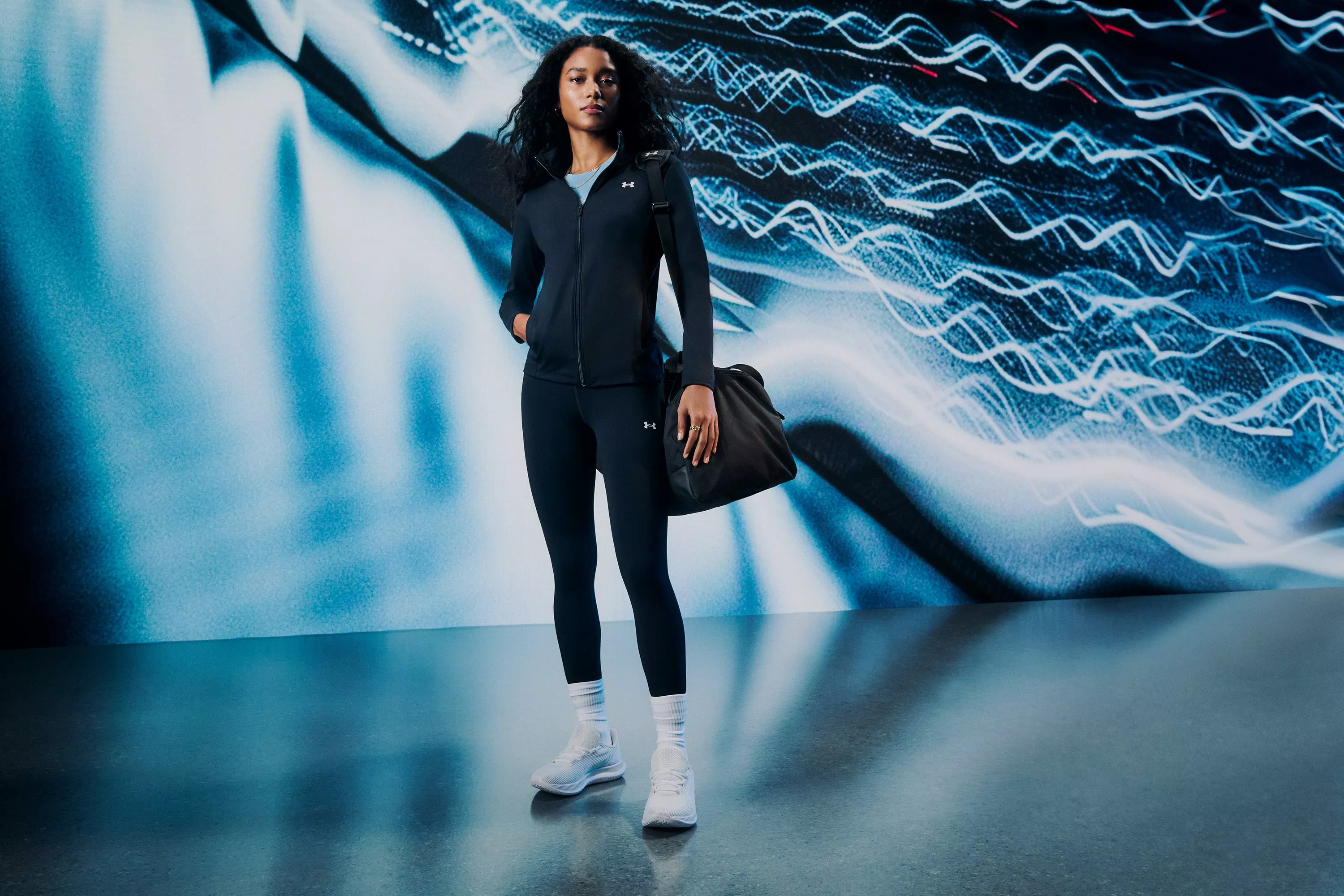 Woman wearing white trainers with jacket, leggings and bag