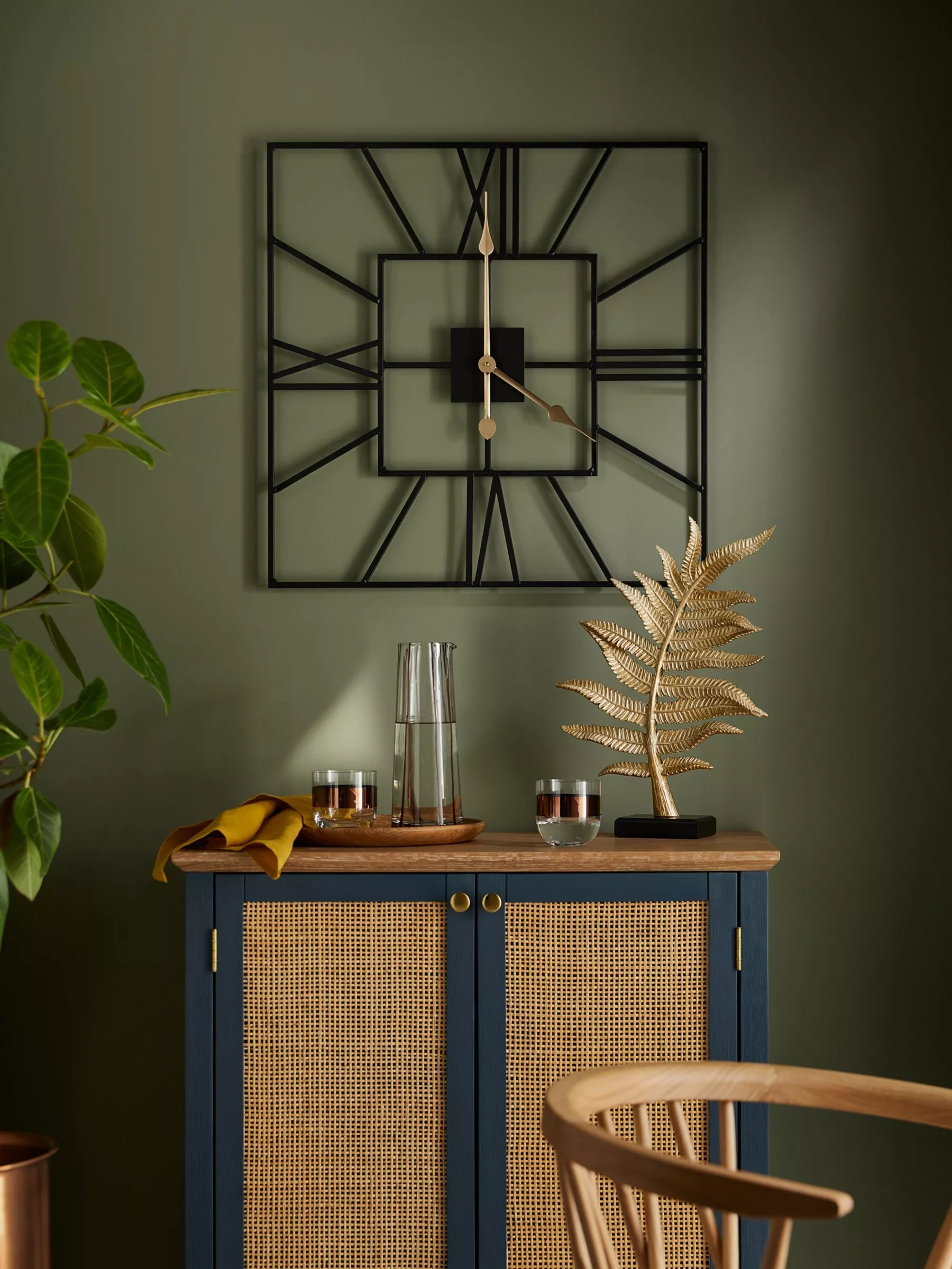 square clock on green wall