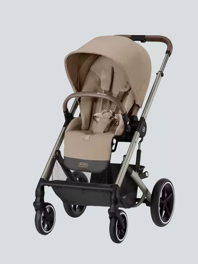 A beige baby stroller with a sleek design, featuring a sturdy frame, four wheels, and a comfortable seat.