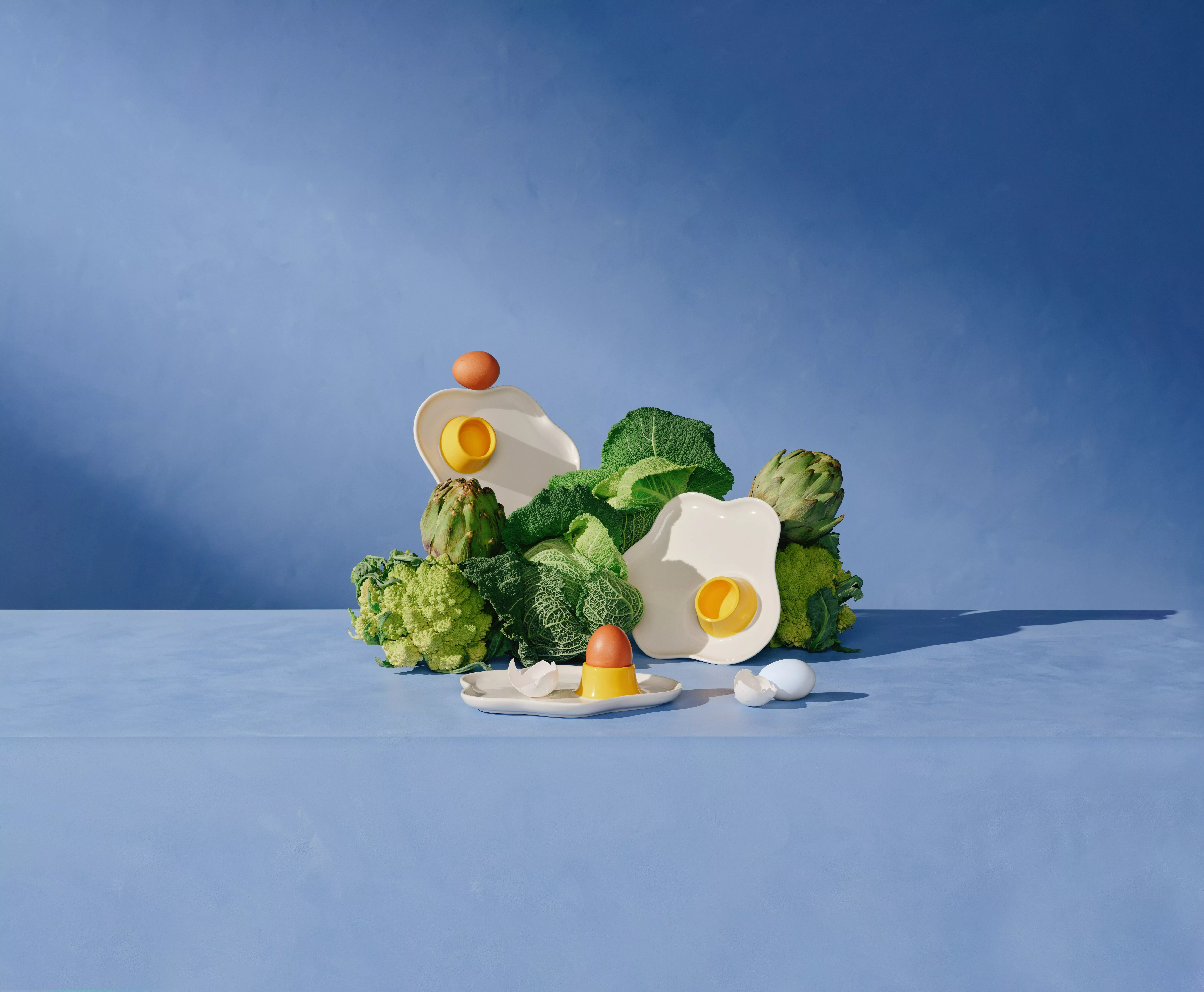A beautifully arranged table with vibrant flowers, candles, ceramics, and glassware. Elegant and colourful setting.