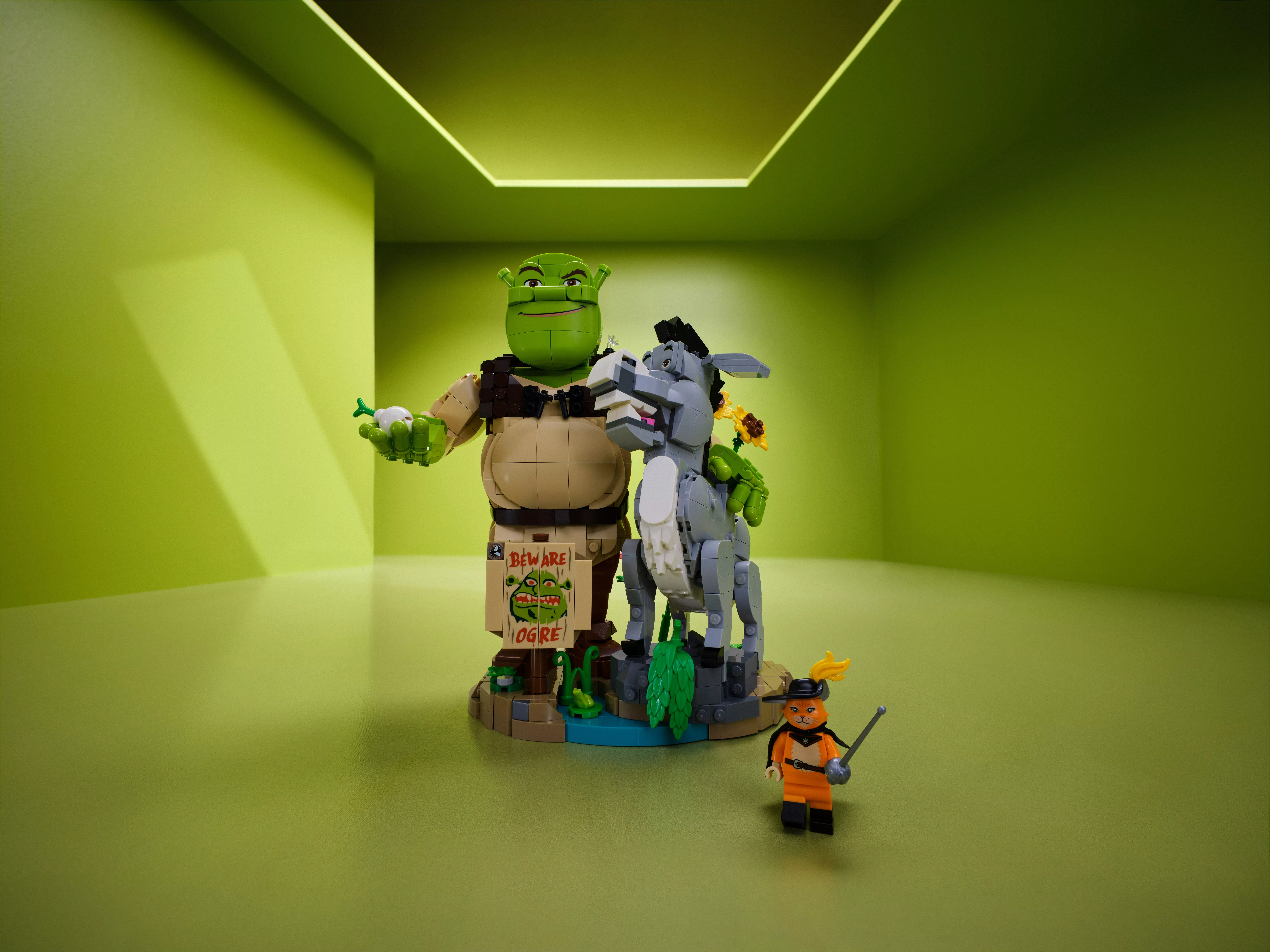 LEGO Shrek display model with Donkey and Puss in Boots minifigure, posed in a green studio setting