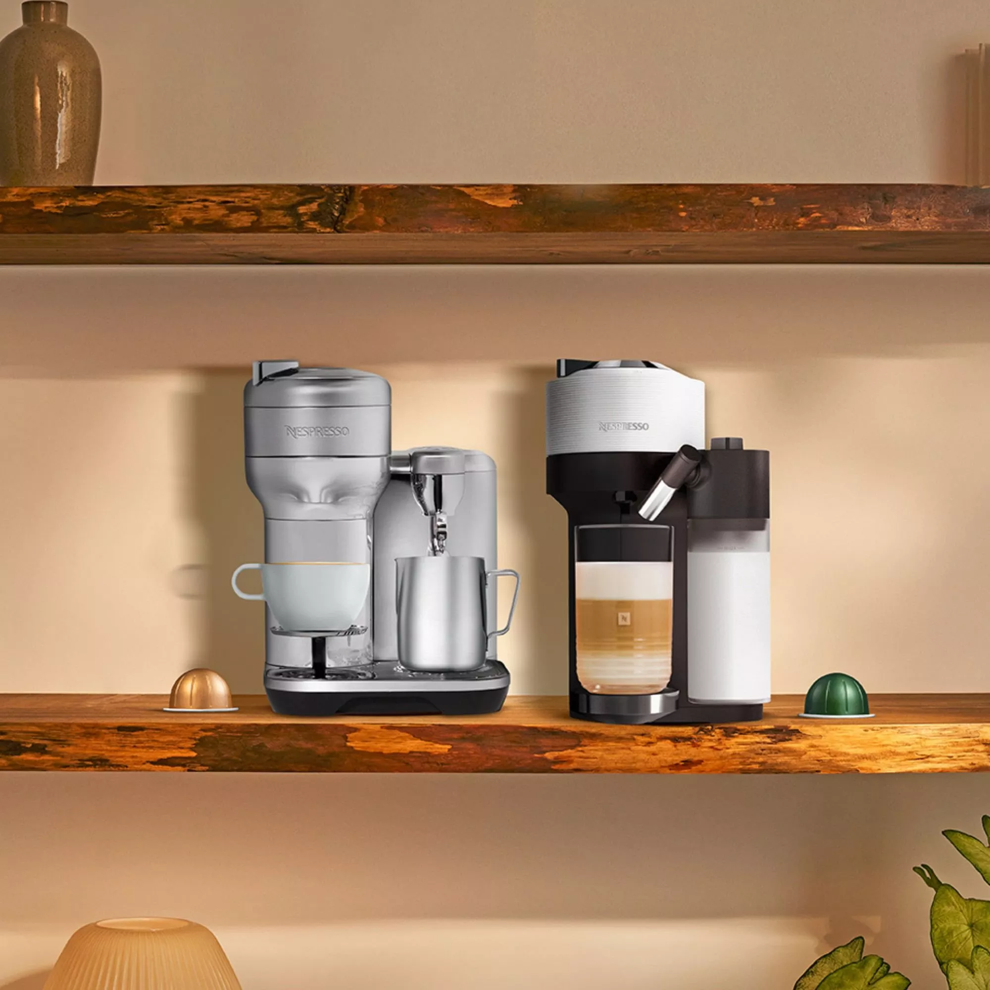 Two coffee machines with milk frothers on a shelf