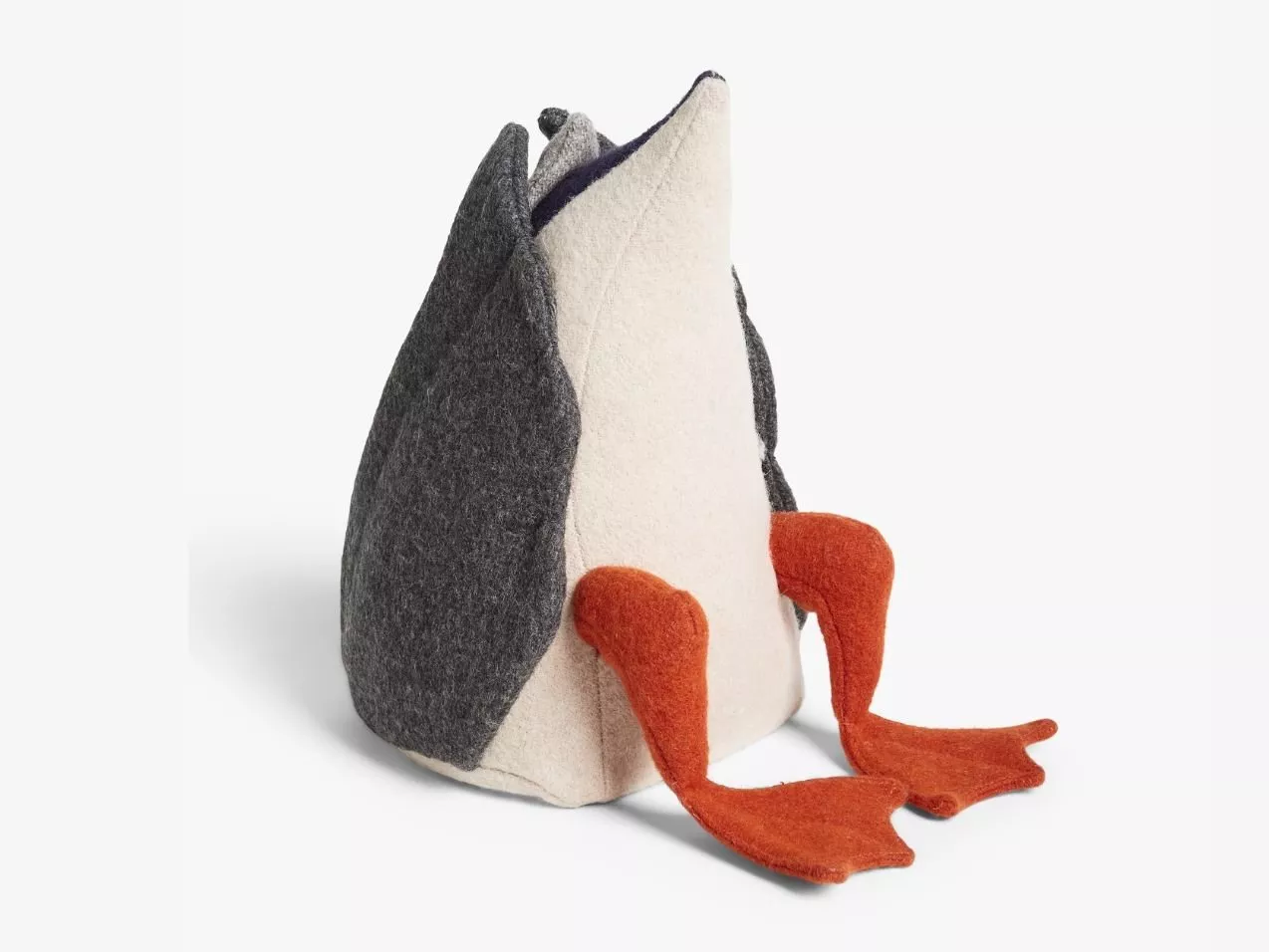 Grey and cream felt penguin soft toy with orange feet, sitting upright on a white studio background