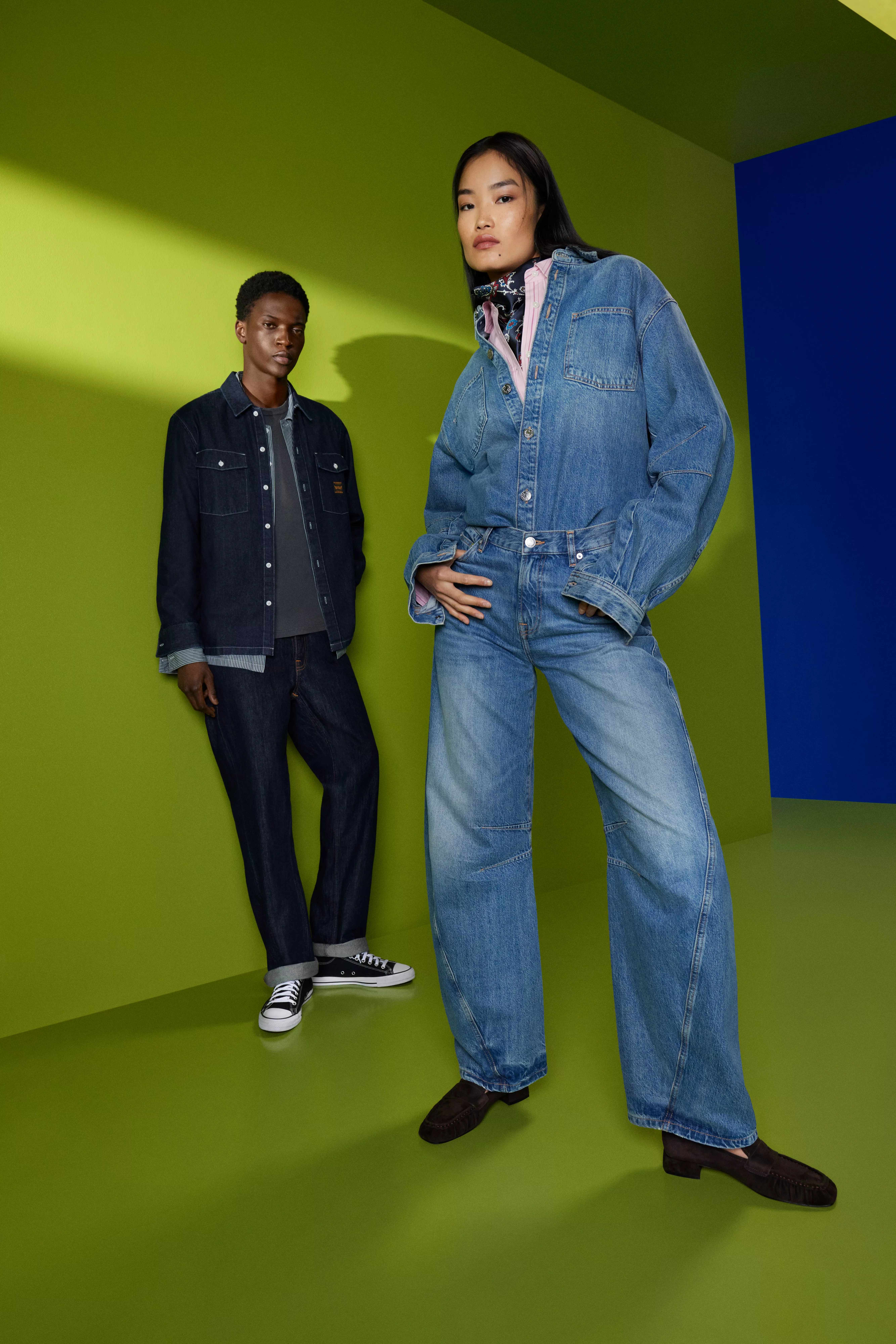 Woman in the foreground wearing a denim shirt, with a man in the background wearing a denim shirt