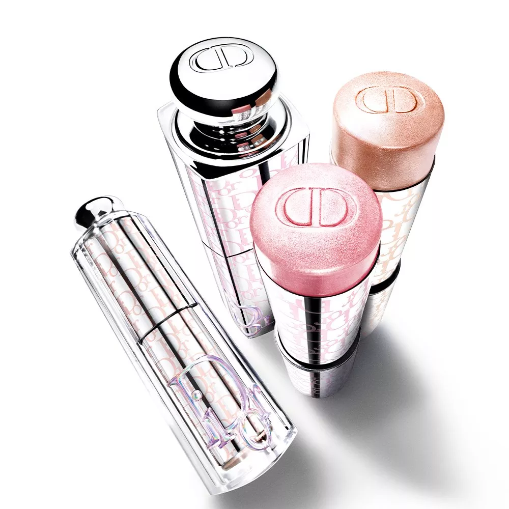 Dior makeup collection on white background, featuring lipstick tube and two shimmer blush sticks with CD logo