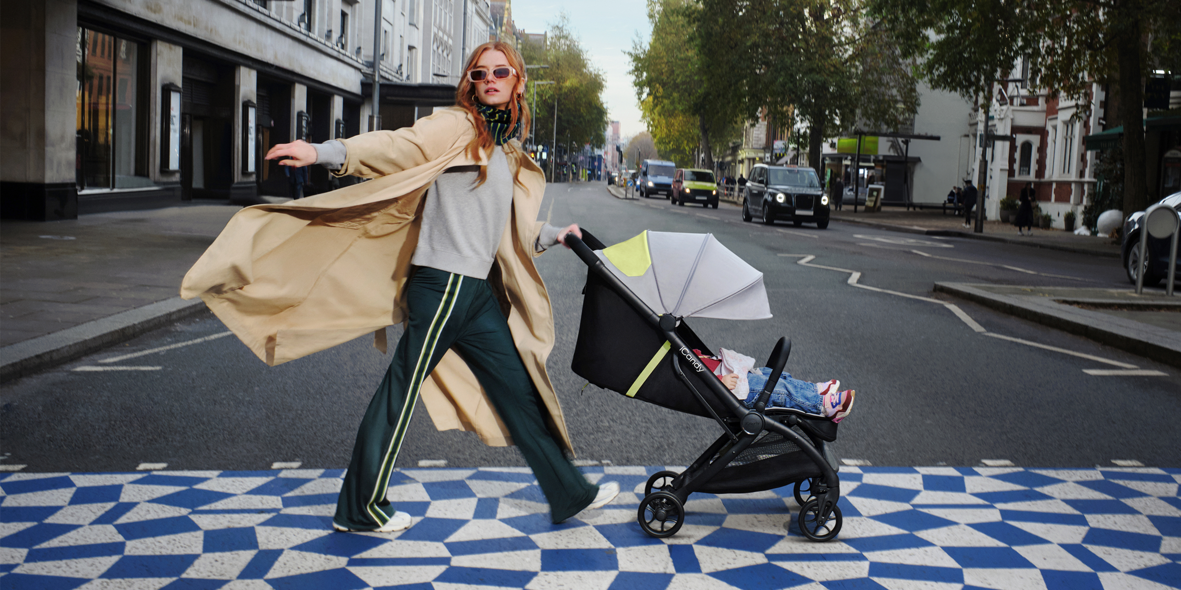 a women crossing a road in a city pushing a iCandy pushchair looking stylish