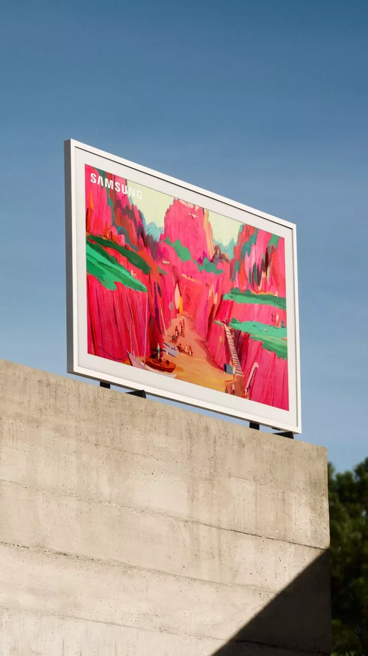 Samsung TV displays vibrant landscape art against a clear blue sky, mounted on a concrete structure.