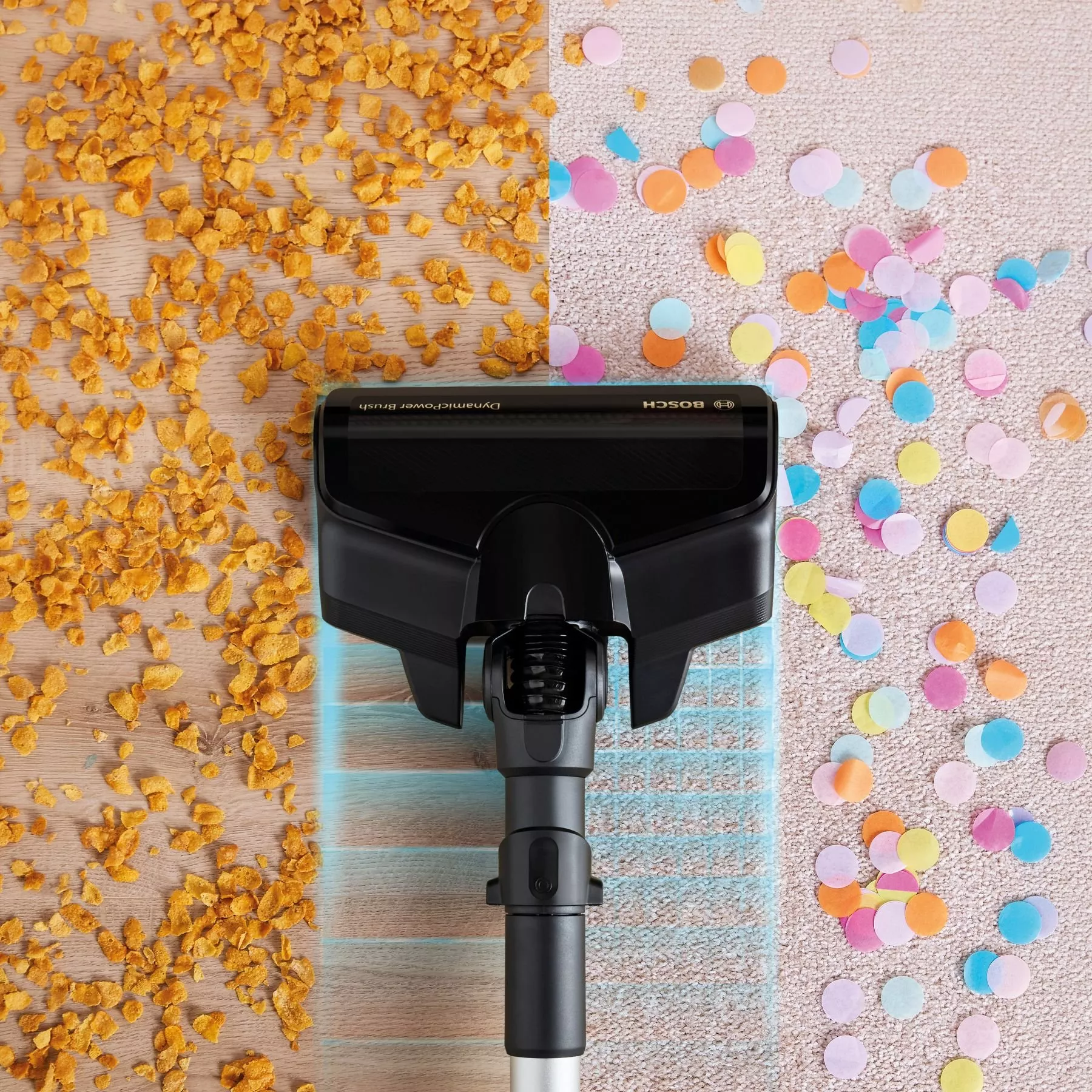 Vacuum cleaner head picking up cereal crumbs on wooden floor and confetti on carpet, powerful cleaning demo