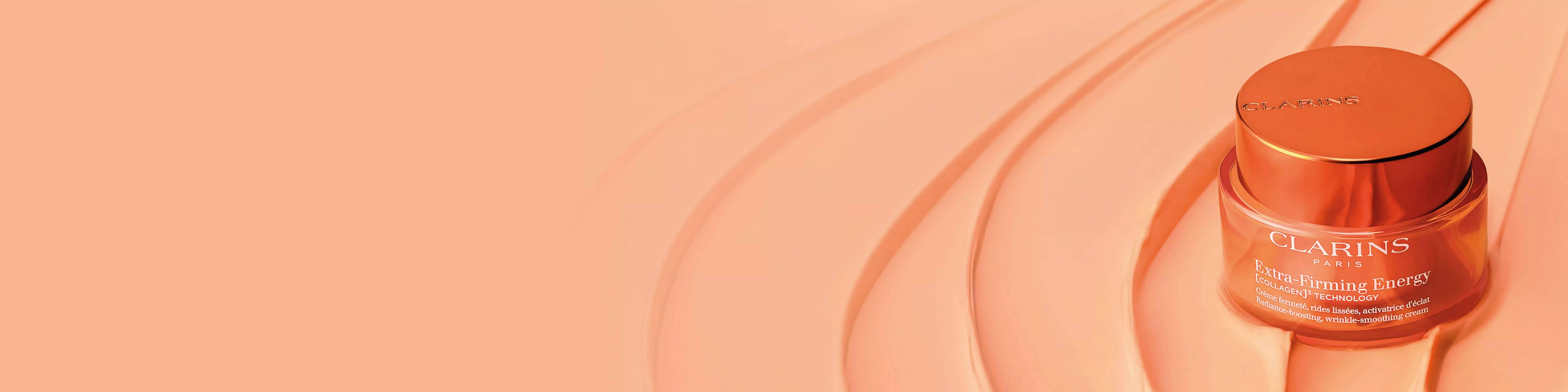 Clarins face cream jar with orange lid on a stylish textured background, promoting skincare and beauty.