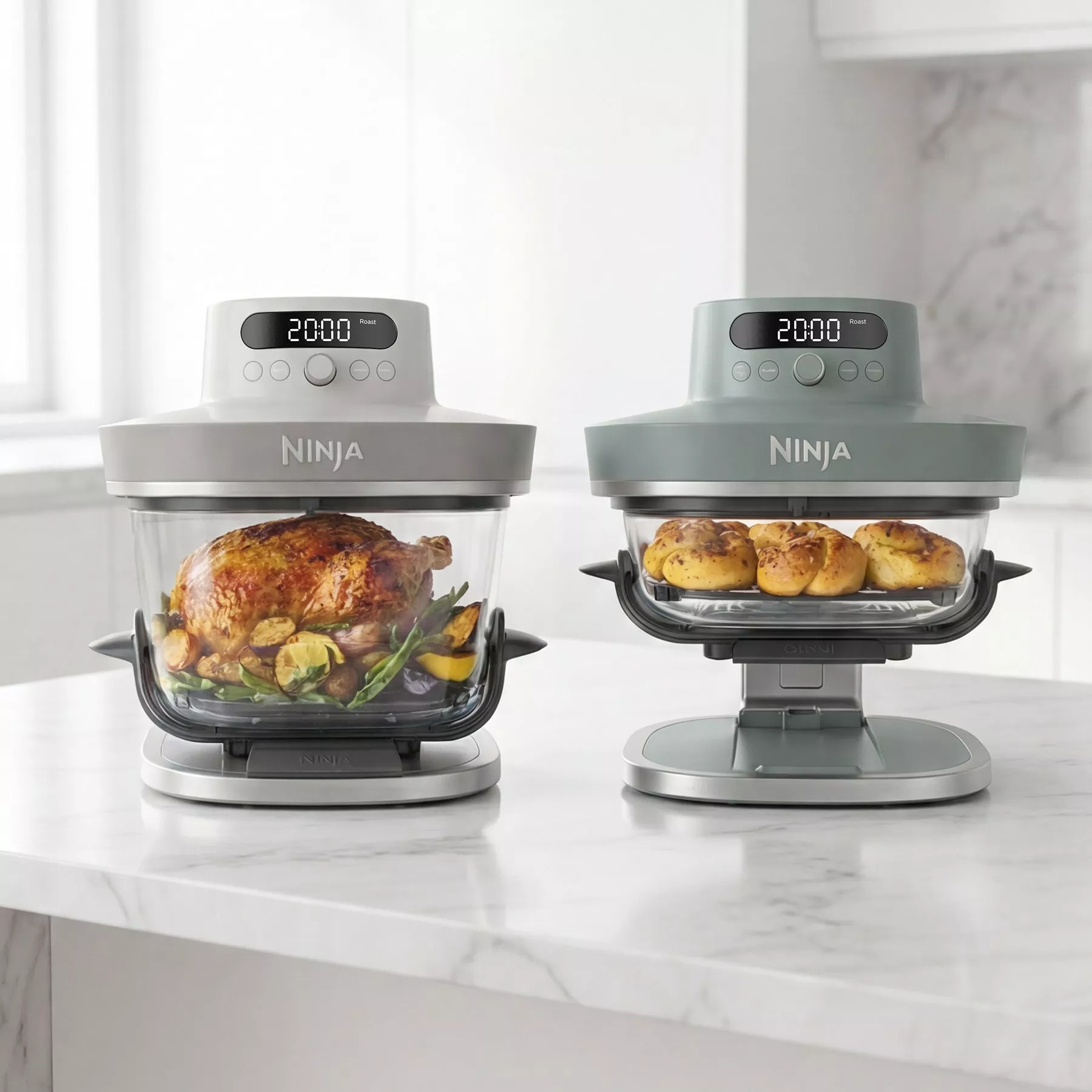 Modern kitchen scene featuring Ninja appliances with roasted chicken and bread rolls on a marble countertop.