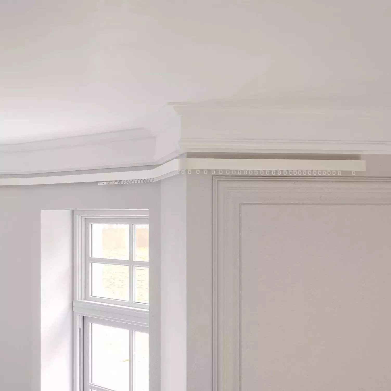 White ceiling cornice and curtain track above sash windows in a bright, modern living room interior.