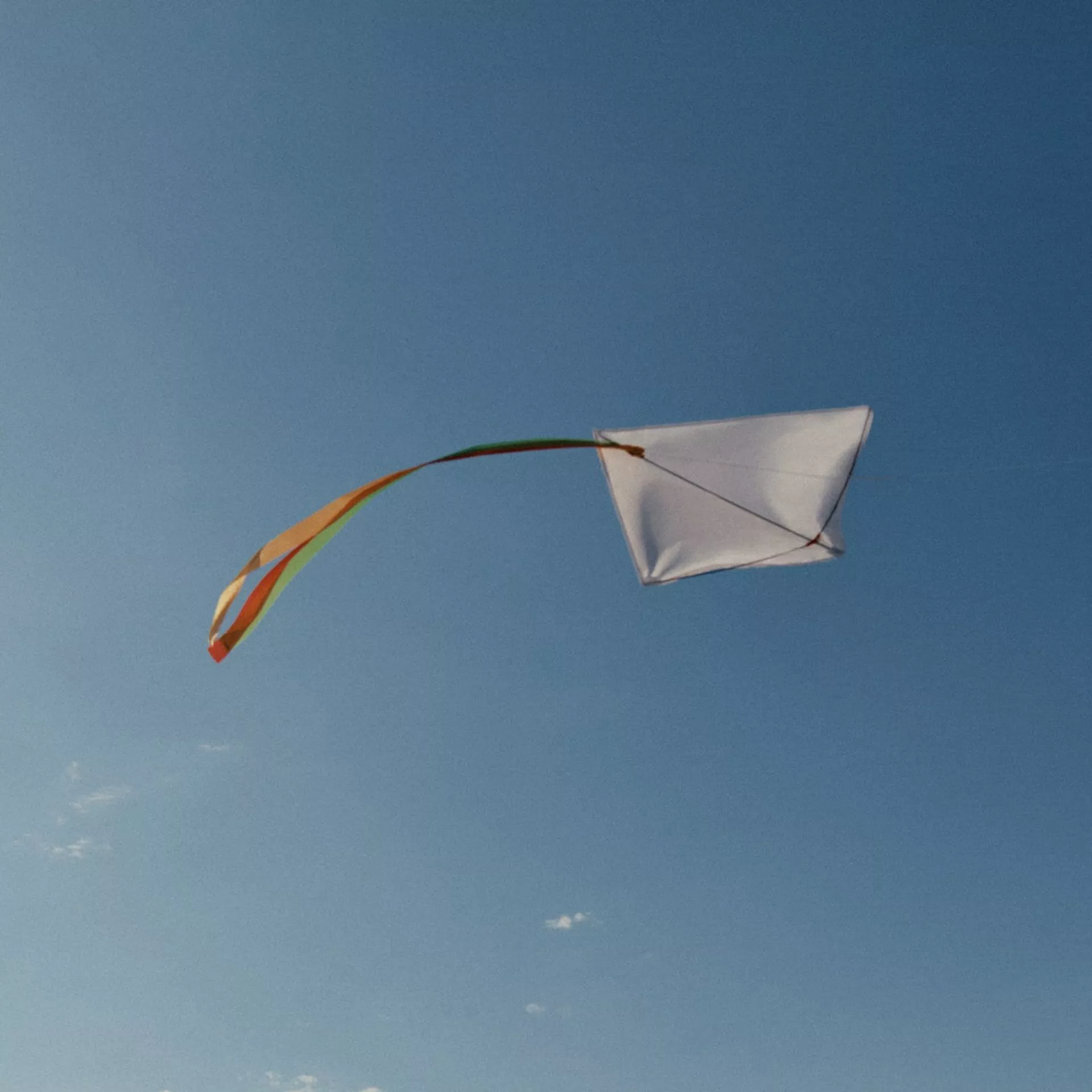 Two people on a beach, one in blue holding a ball, the other in orange. Waves and clear sky in the background.