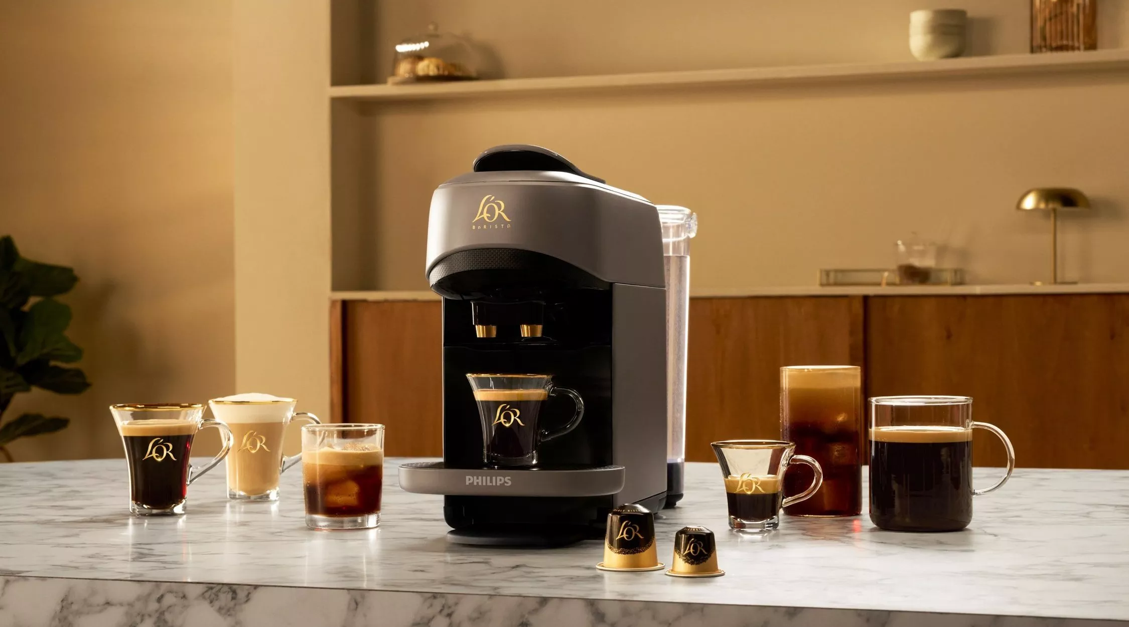 Elegant coffee machine with branded cups and capsules on a marble counter, creating a cosy and inviting atmosphere.