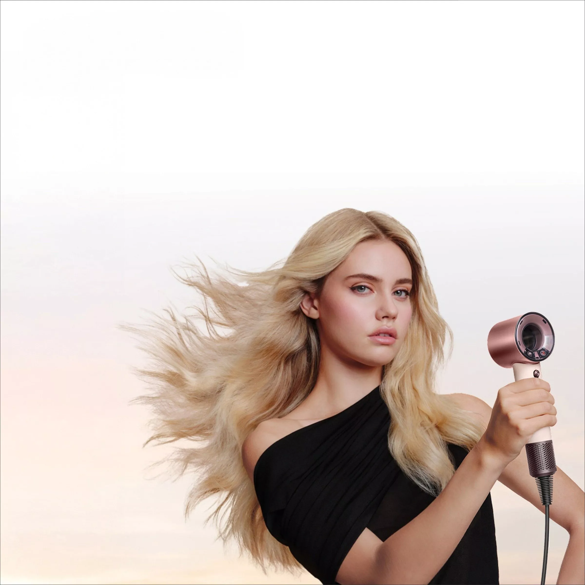 Dyson Supersonic hair dryer advert with blonde model blow-drying hair, showcasing fast drying travel styling