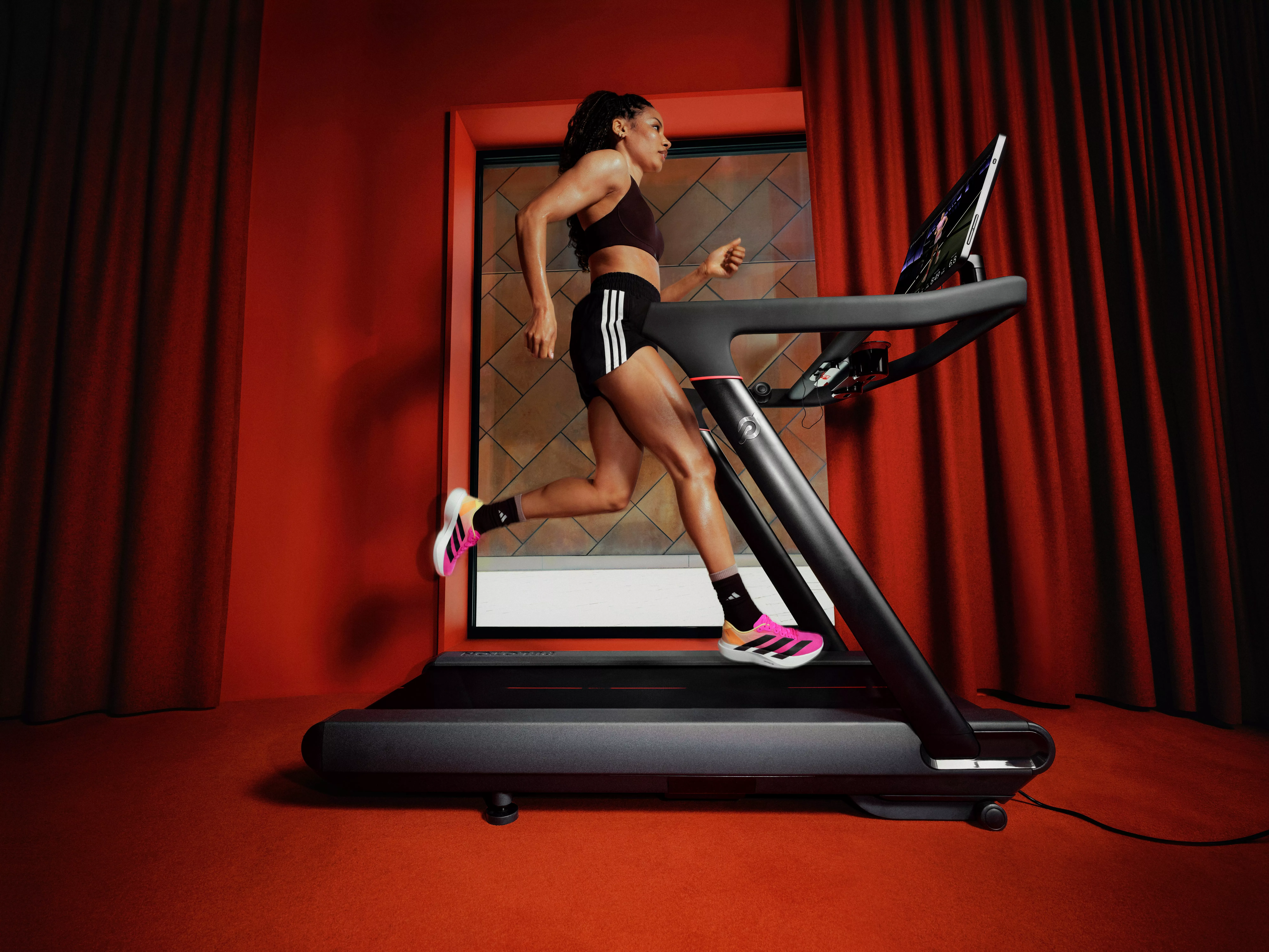 Woman running on a smart treadmill in a modern home gym, cardio workout with touchscreen fitness display