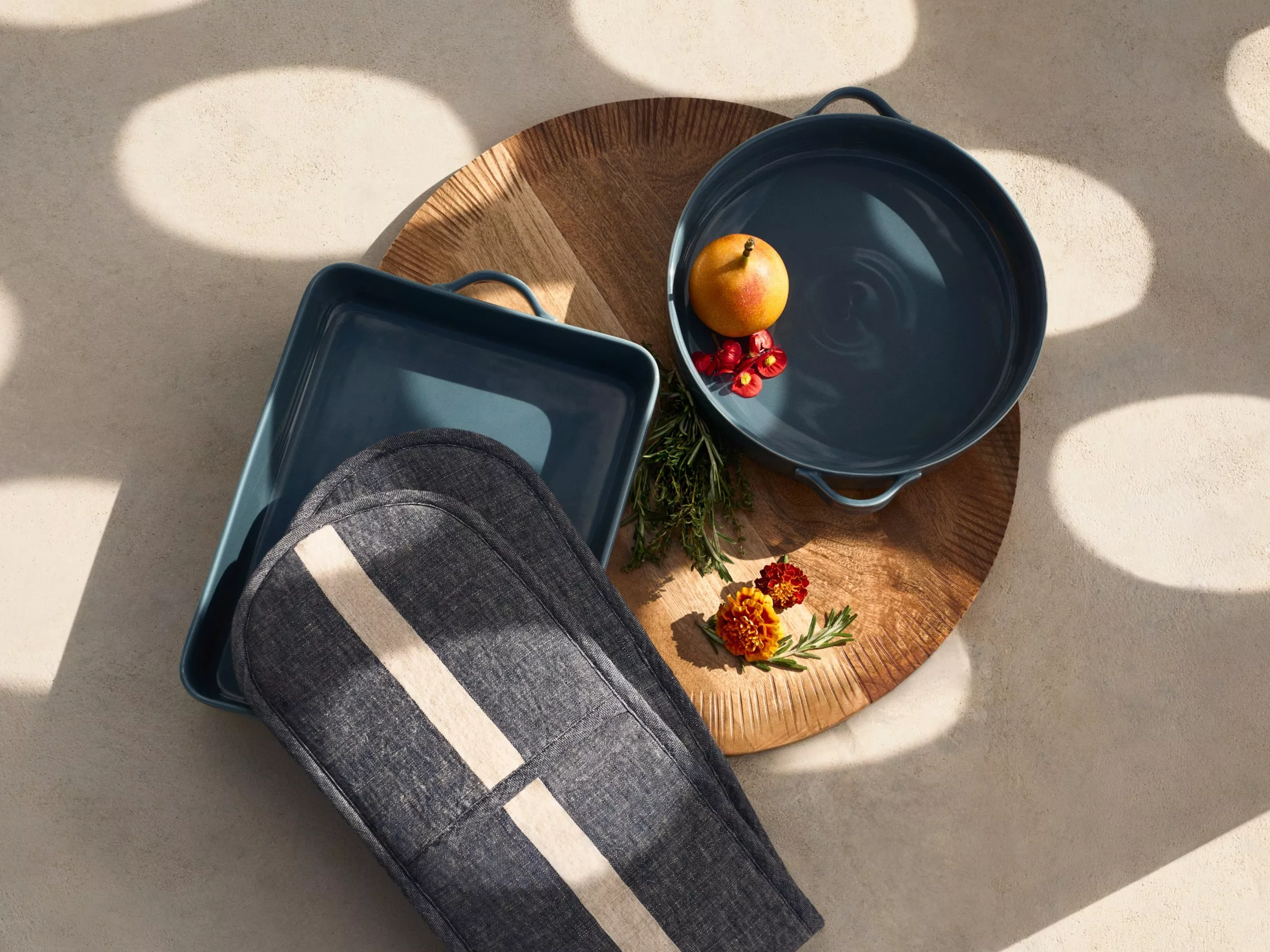 product shot of 2 carasols pans and a woodern chopping board