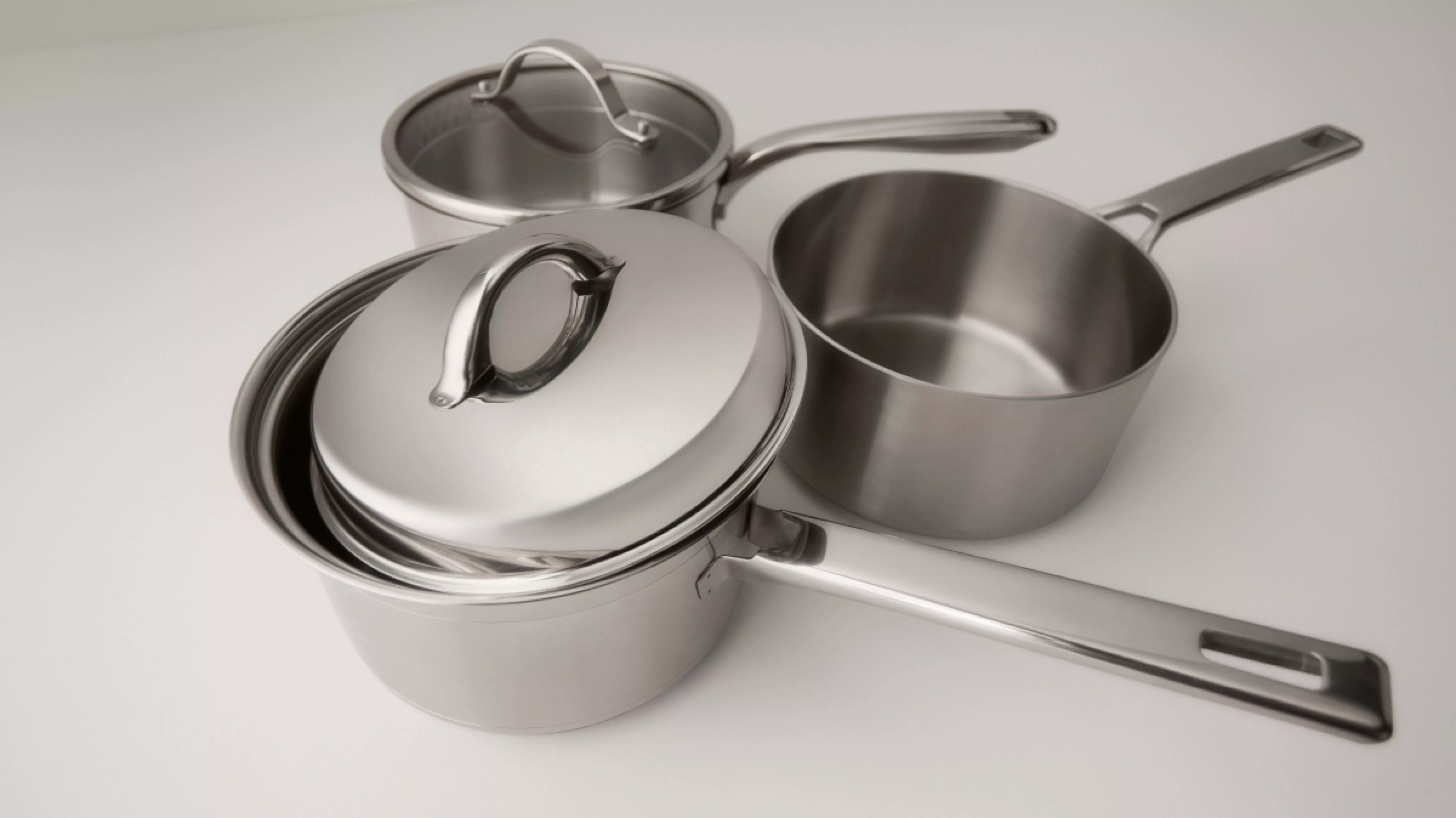 Stainless steel saucepan set with lids and long handles, modern cookware for home kitchen cooking on hob