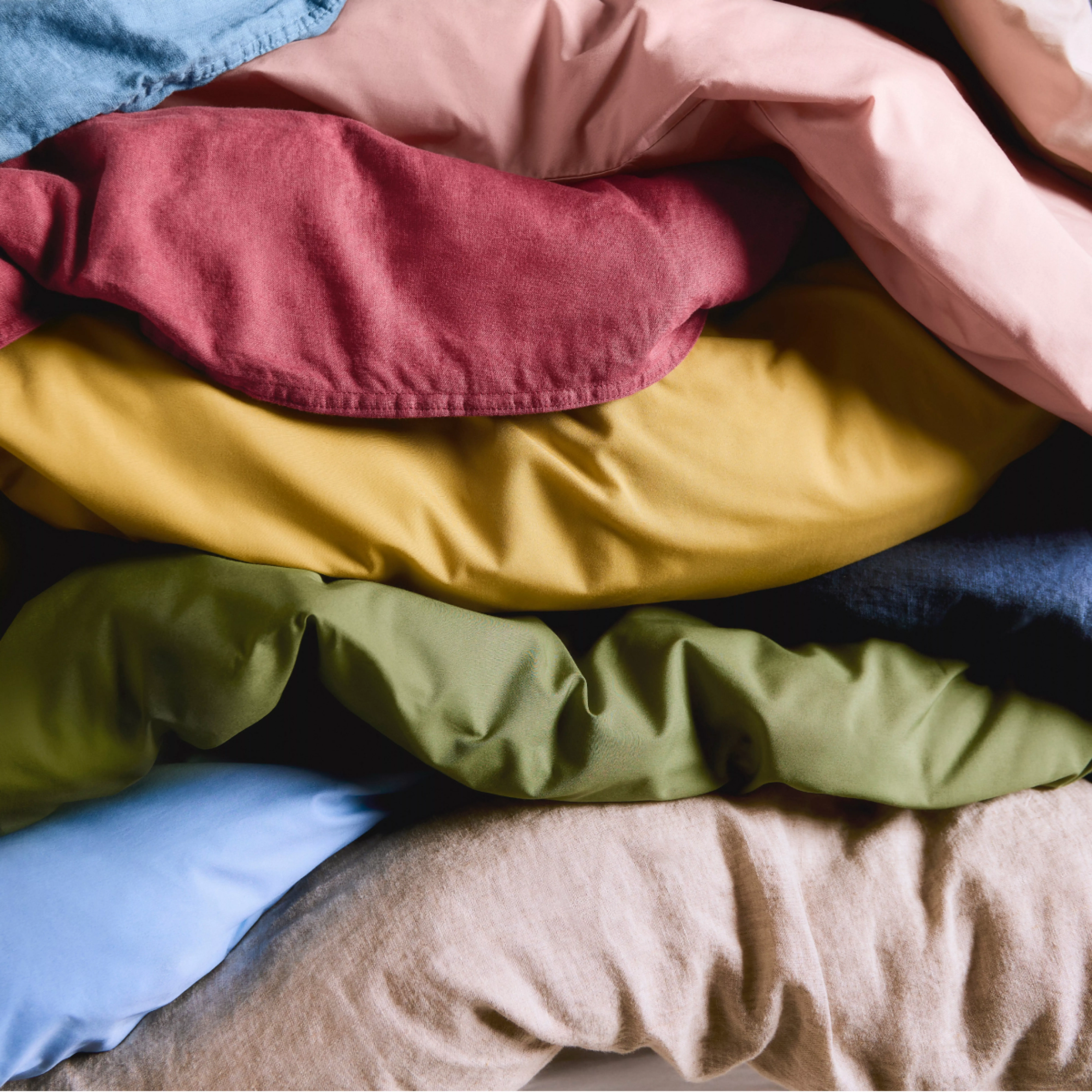 Stacked colourful pillows and cushions in soft fabrics, cosy home decor texture close-up for bedroom styling