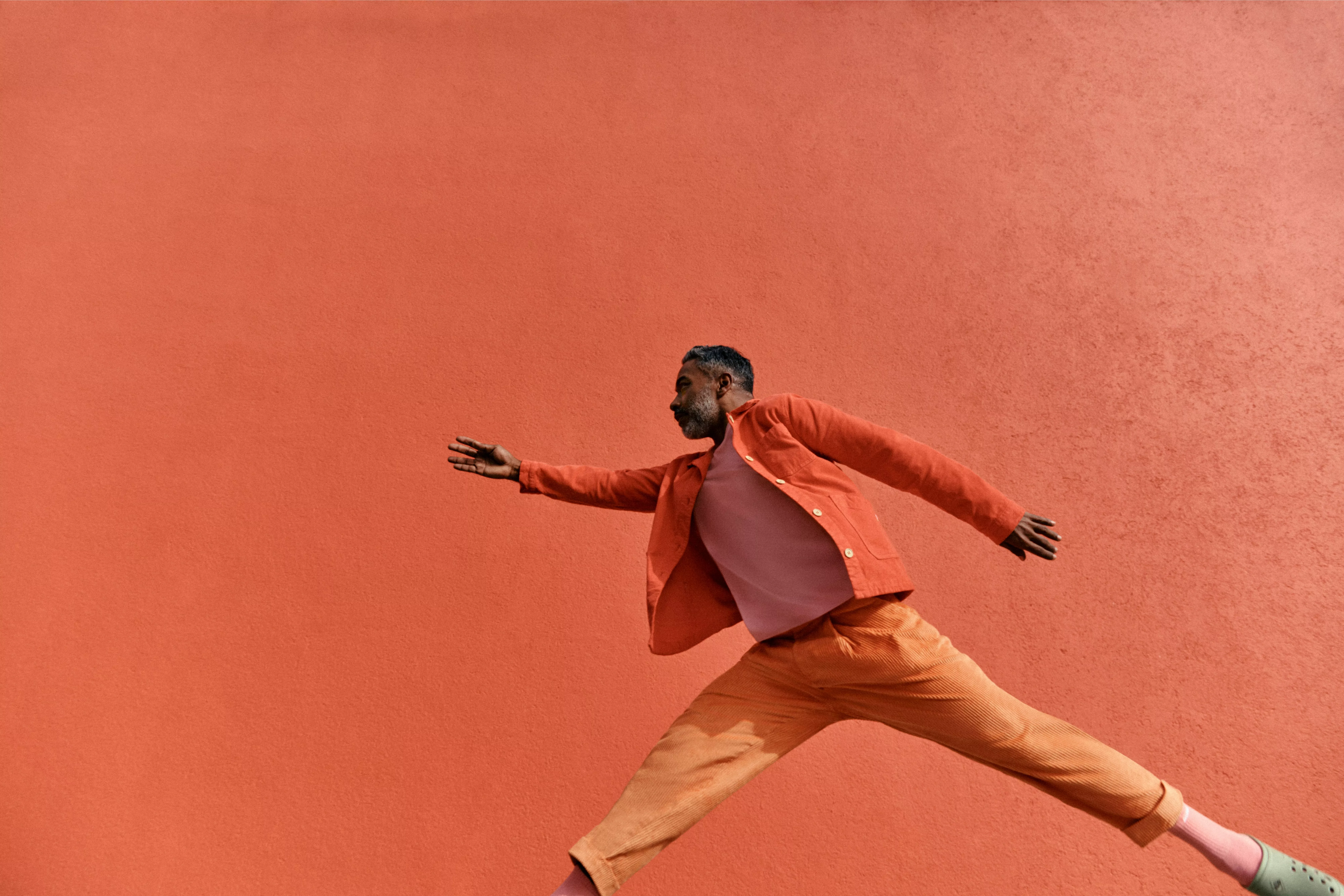 John Lewis Money advert with man leaping across orange background and text saying “Say hello to John Lewis Money”