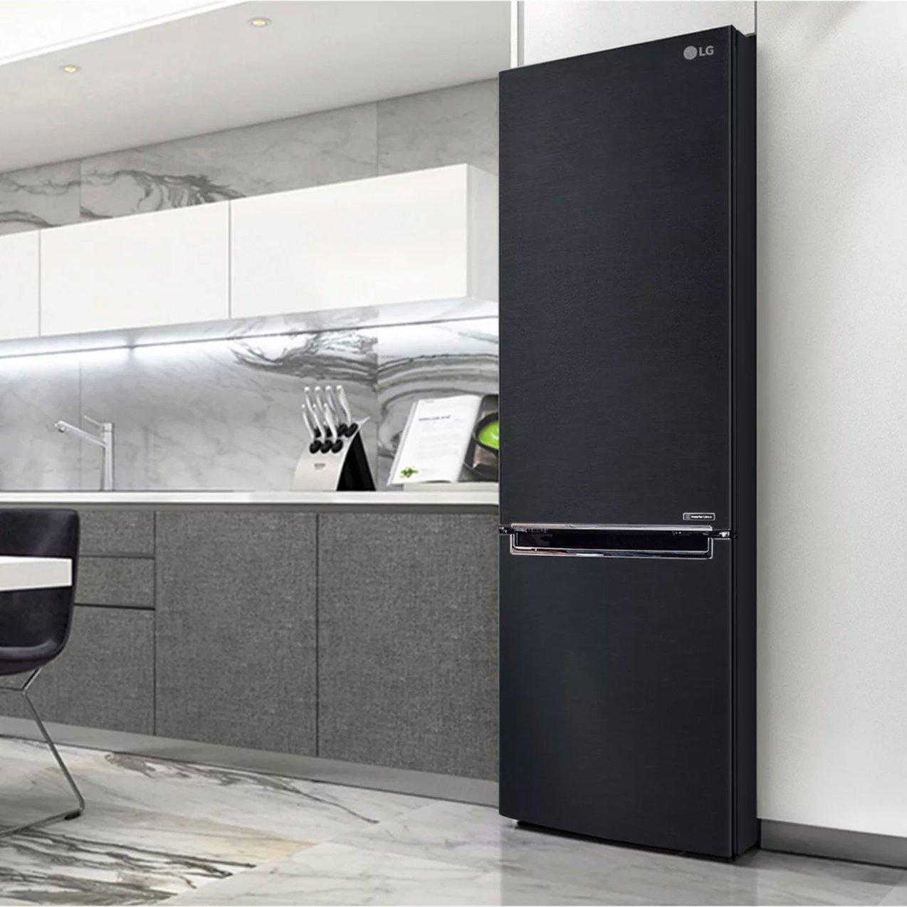 A tall, modern black LG refrigerator standing in a contemporary kitchen with a marble backsplash and grey cabinetry.