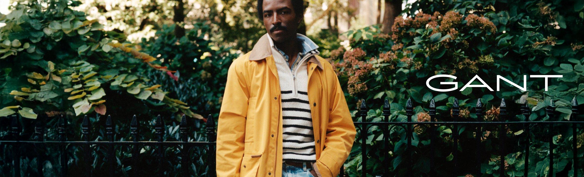 man wearing a cream jumper and a yellow gant jacket