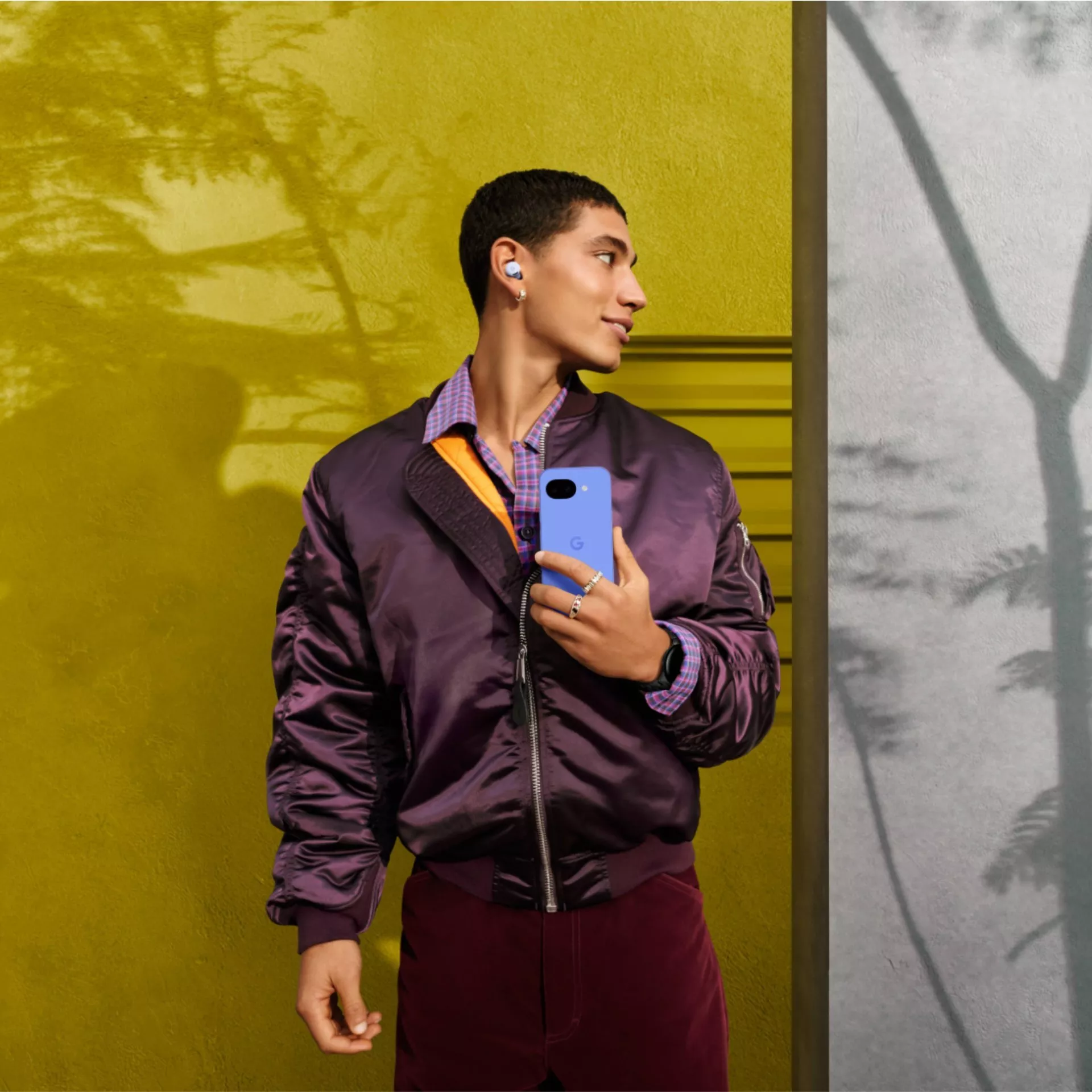 Person holding an Apple iPhone with triple camera, close-up portrait shot in a modern indoor setting